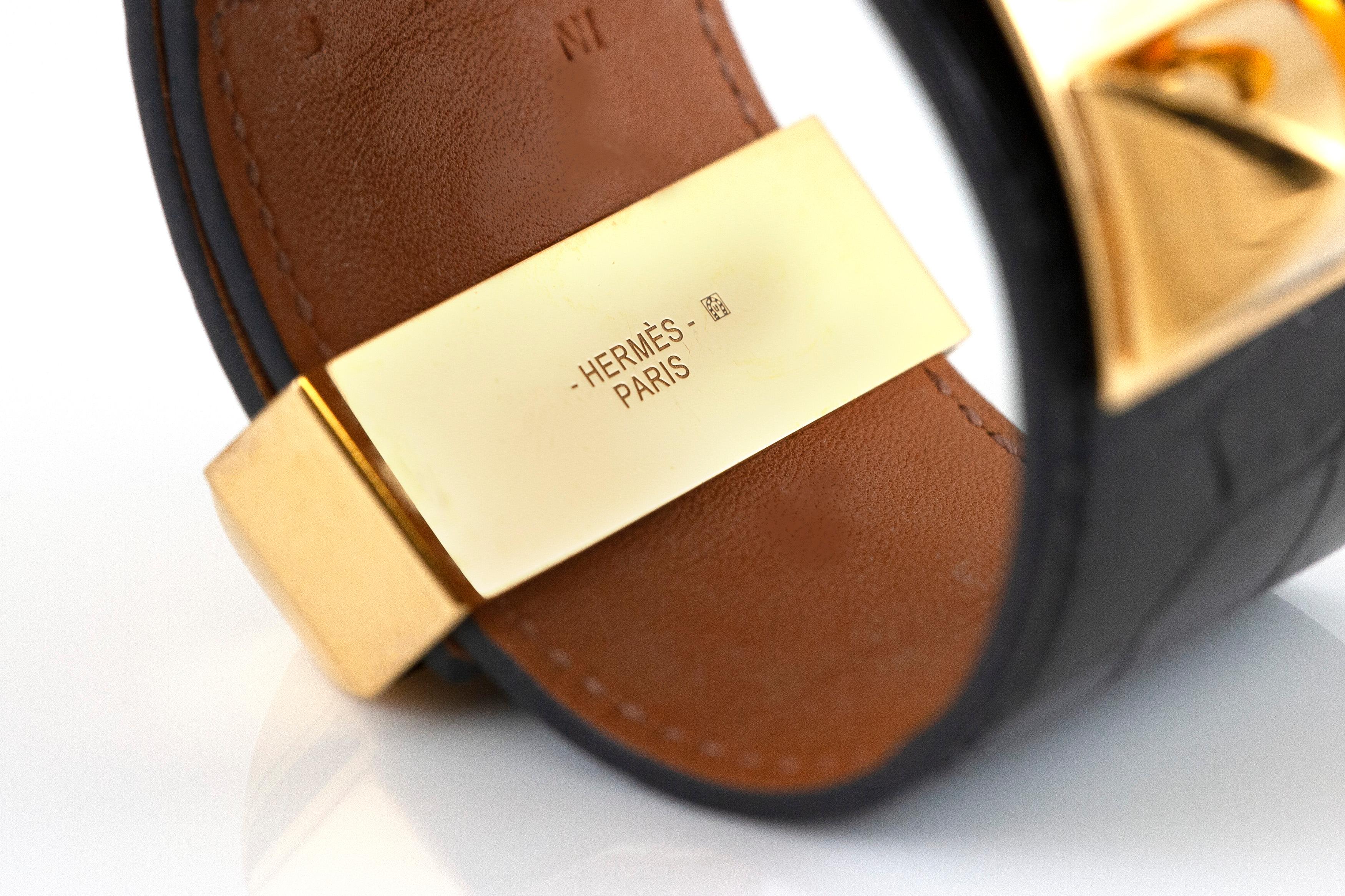 The cuff bracelet from black lizard leather and on top 18k gold.

Sign Hermes