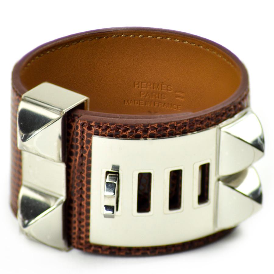 Die Manschette ist ein zeitloses Modell aus dem Hause HERMES. Es handelt sich um ein Hundehalsband aus geglättetem etruskischem Niloticus-Eidechsenleder. Die Beschläge der Manschette sind aus Palladiumsilber.
Das Armband ist in sehr gutem Zustand,