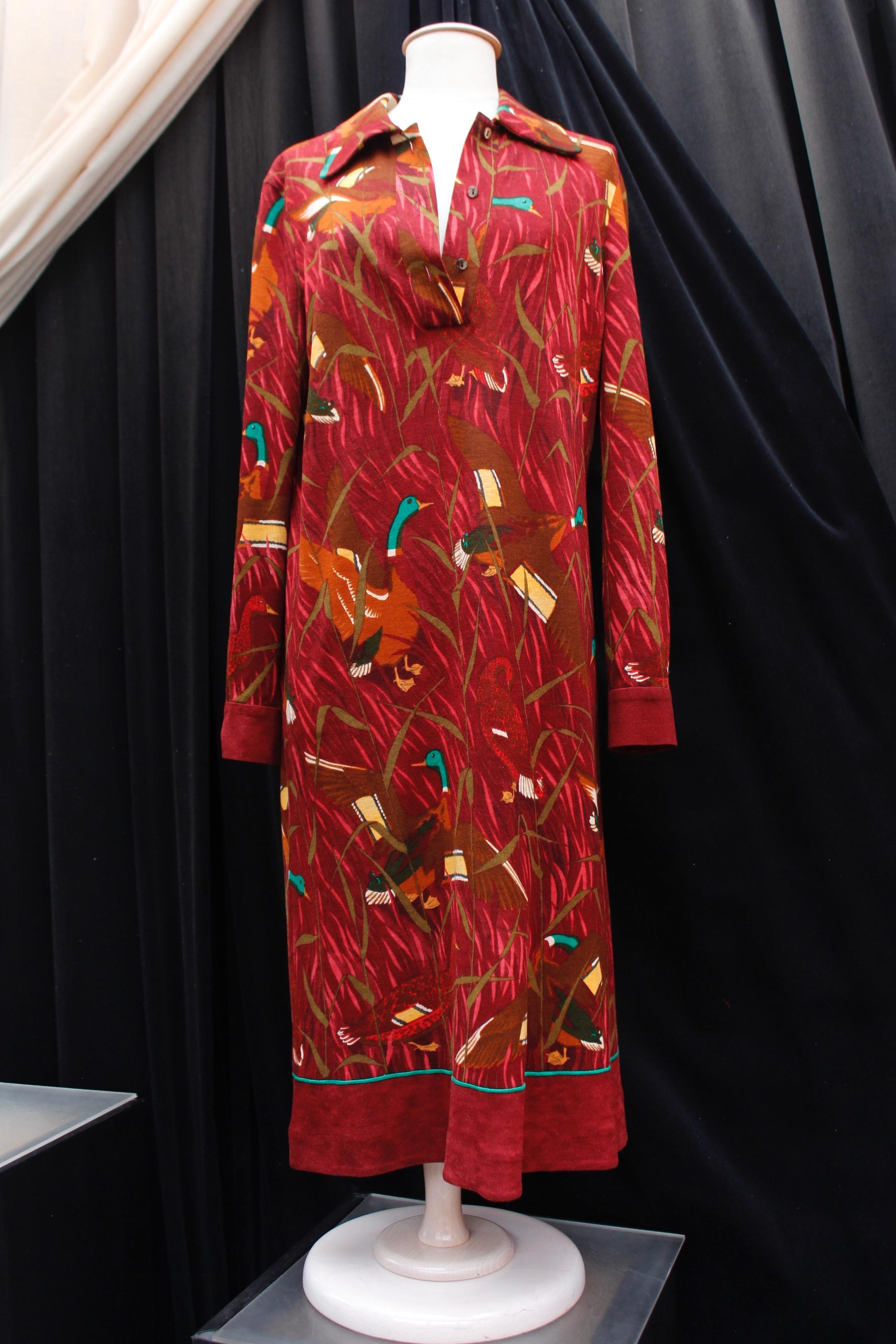 HERMES PARIS (Made in France) Long sleeve long dress composed of burgundy wool with “Cols Verts” print created by Christiane Vauzelles in 1973. The collar opens with three bakelite buttons. A matching cord can be tied around the neck or the waist.