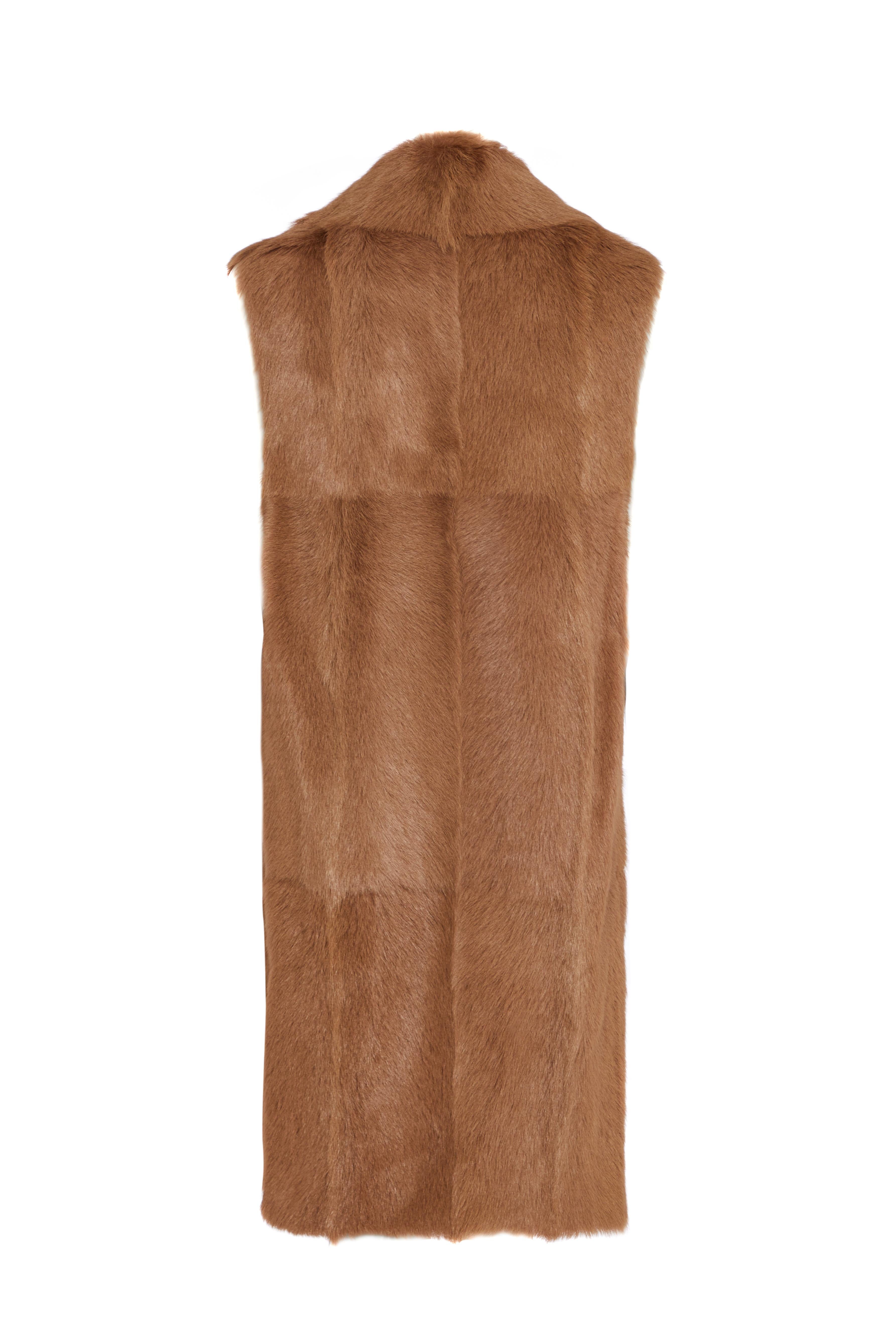 This is a beautiful goat fur gilet by Hermès. It features side slits and a small leather button closure at the front. Please inquire for any further details. 