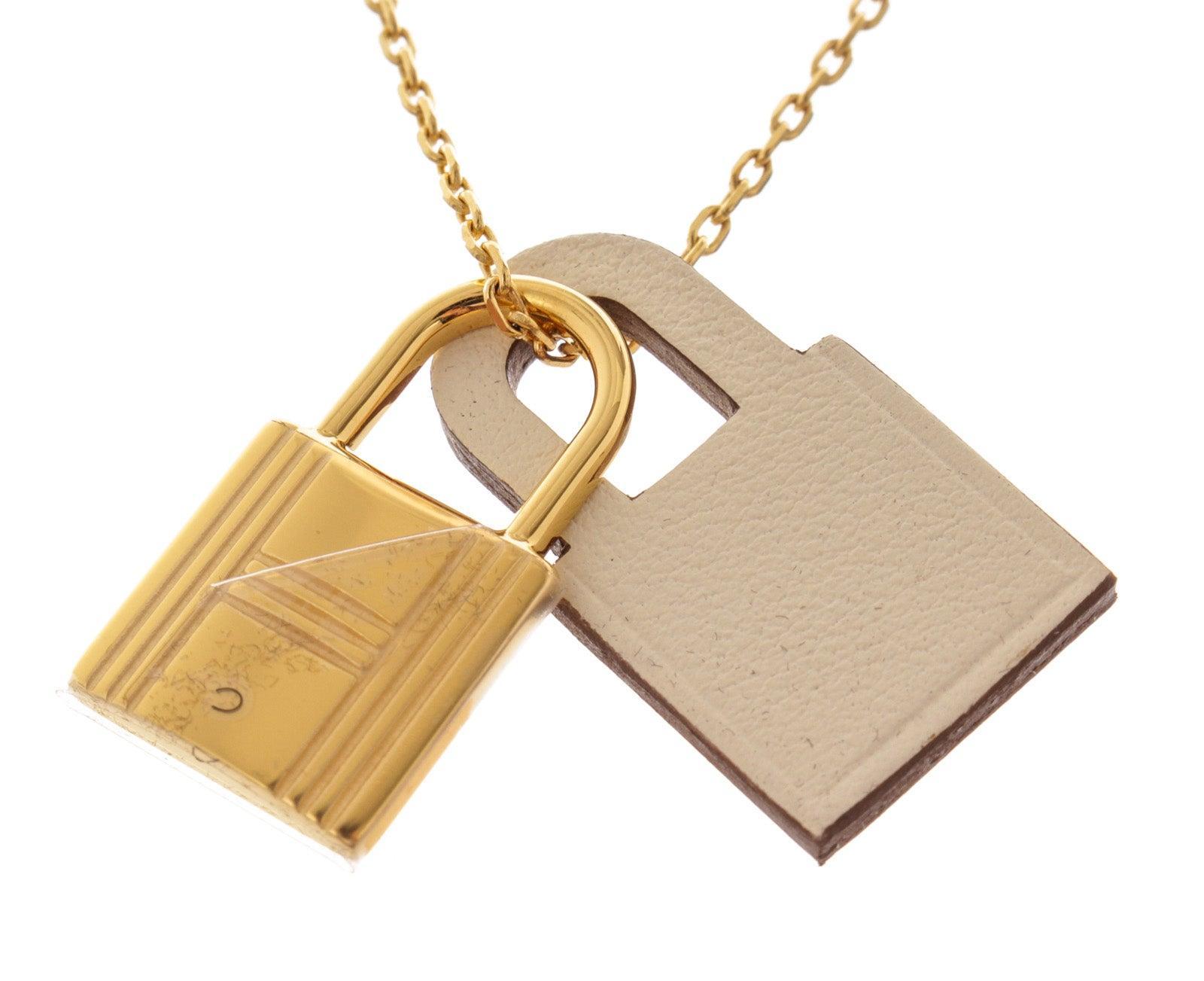 Hermes long necklace with Pendant in Swift with gold-plated hardware. The O'Kelly line gives pride of place to the eponymous bag padlock. Here, it's streamlined and attached to a stylish leather padlock that follows like a shadow.
 

58174MSC