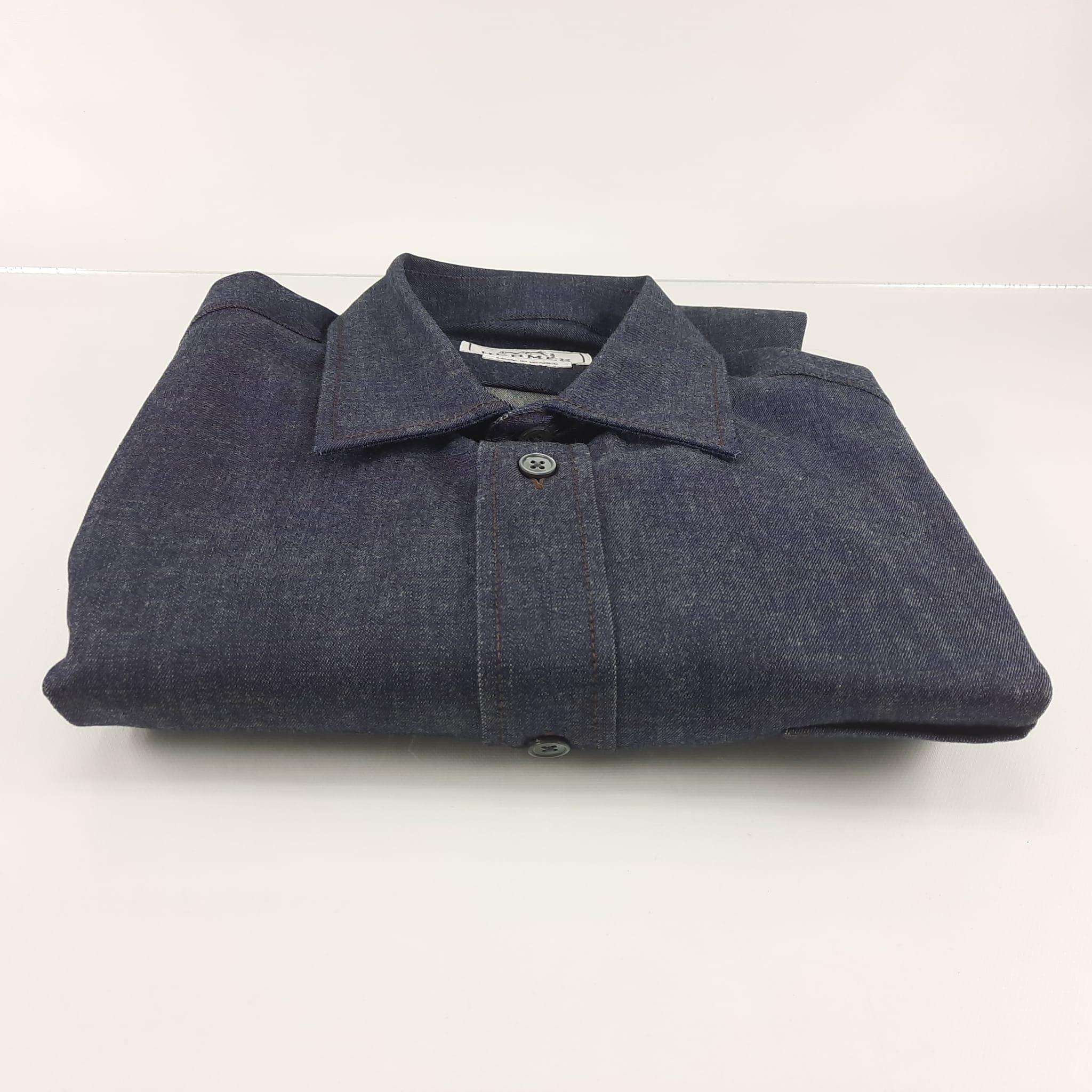 Preloved, never used. Size 39. Sporty fit shirt in denim. Flexible collar. Pure mother-of-pearl buttons and plain cuffs with palladium-plated Clou de Selle buttons. Front pocket. Length: 78 cm. PR10214