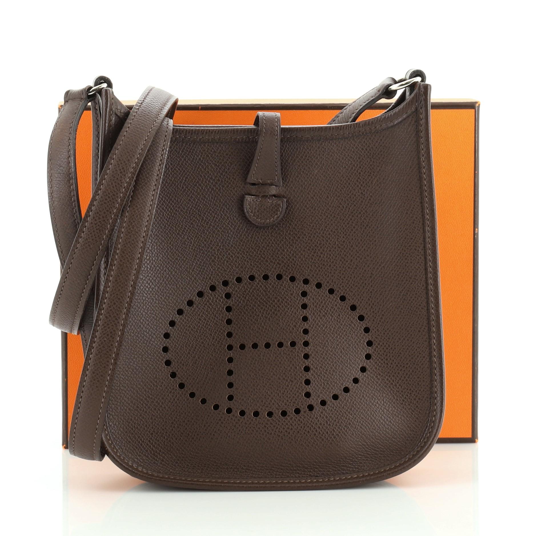 This Hermes Long Strap Evelyne Crossbody Bag Epsom TPM, crafted from Chocolate brown Epsom leather, features perforated H at the front, long shoulder strap and palladium hardware. It opens to a Chocolate brown raw leather interior. Date stamp reads:
