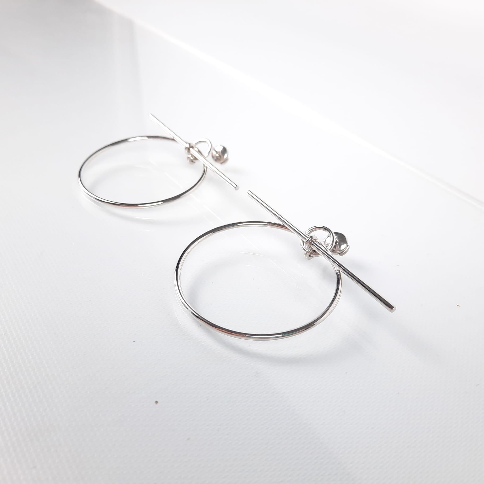 The stick ring, Hermès signature, is transformed into minimalist and graphic earrings.

