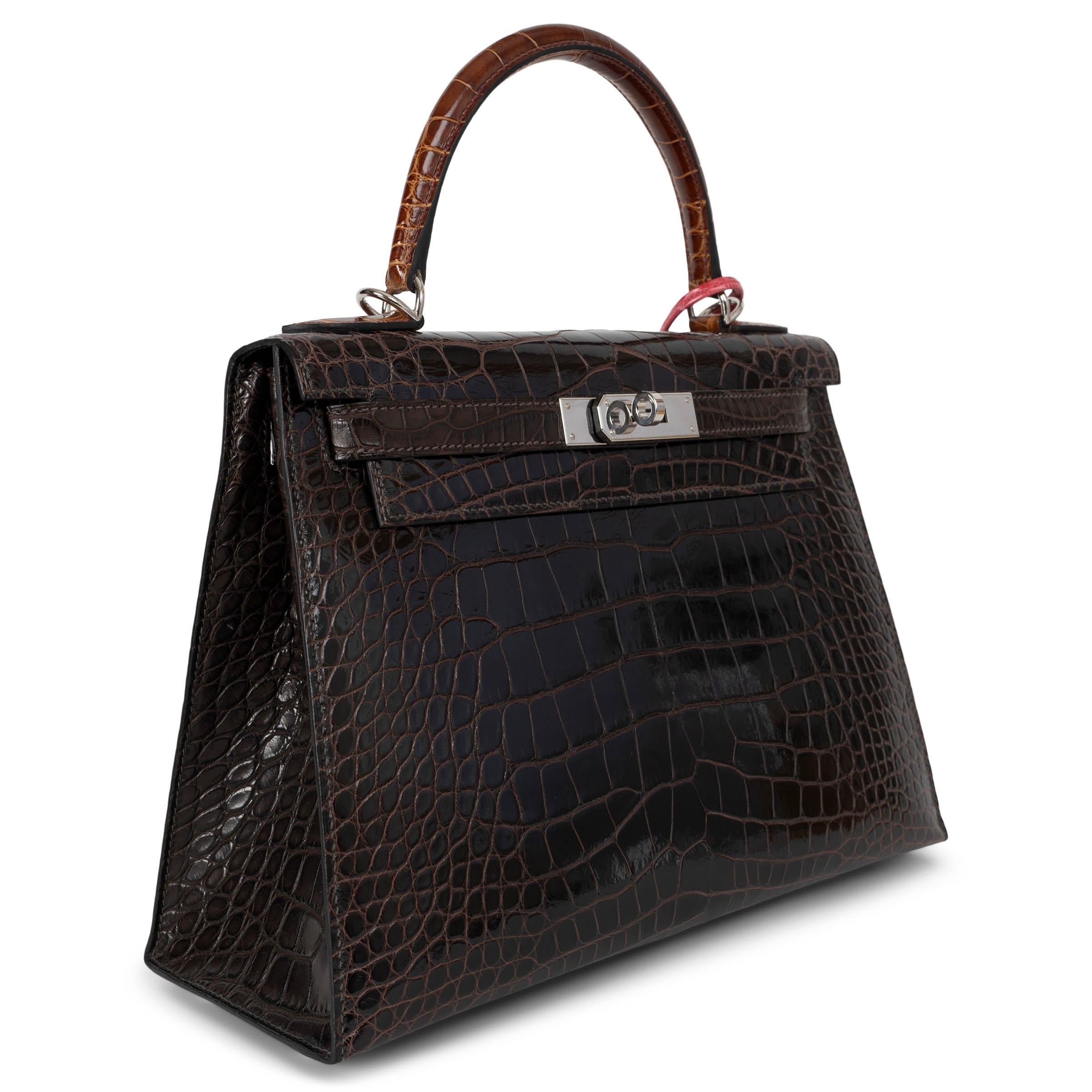 This 100% authentic Hermès Kelly 28 Sellier bag is a truly rare and exquisite piece, crafted in a unique combination of Macassar (dark brown) shiny alligator on the front and back with contrasting Ebene (dark brown) matte alligator on the sides and