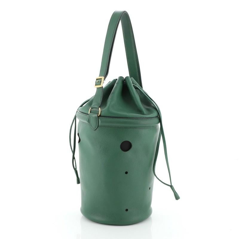 This Hermes Mangeoire Shoulder Bag Courchevel, crafted from Vert Bengale green Courchevel leather, features a leather shoulder strap, laser cut holes and gold hardware. Its drawstring closure opens to a Vert Bengale green raw leather interior. Date