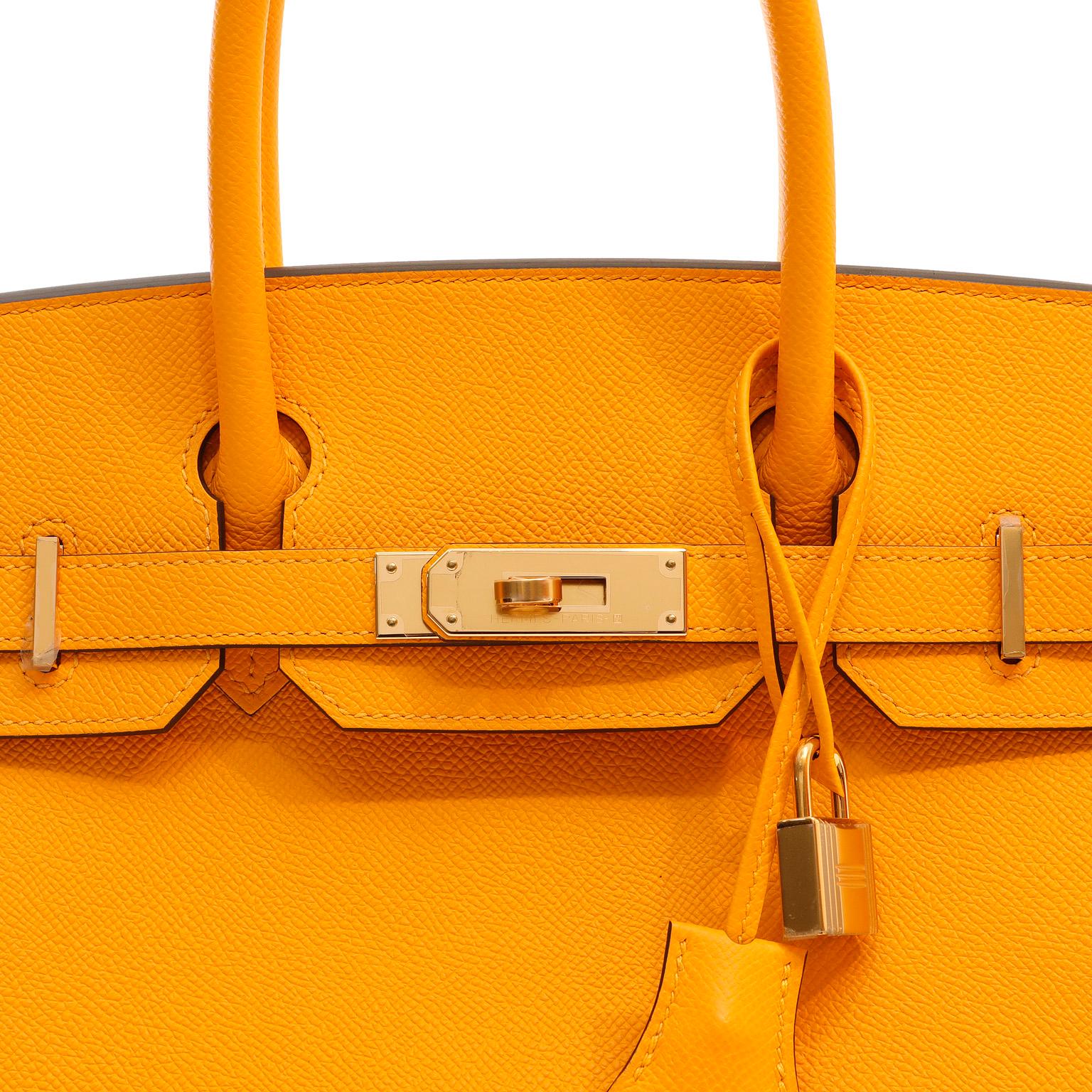 This authentic Hermès Marigold Epsom 30 cm Birkin is in pristine unworn condition with the plastic intact on the hardware. Specially ordered, this rare color is a striking shade of light orange yellow first introduced in 2012.

Epsom leather is