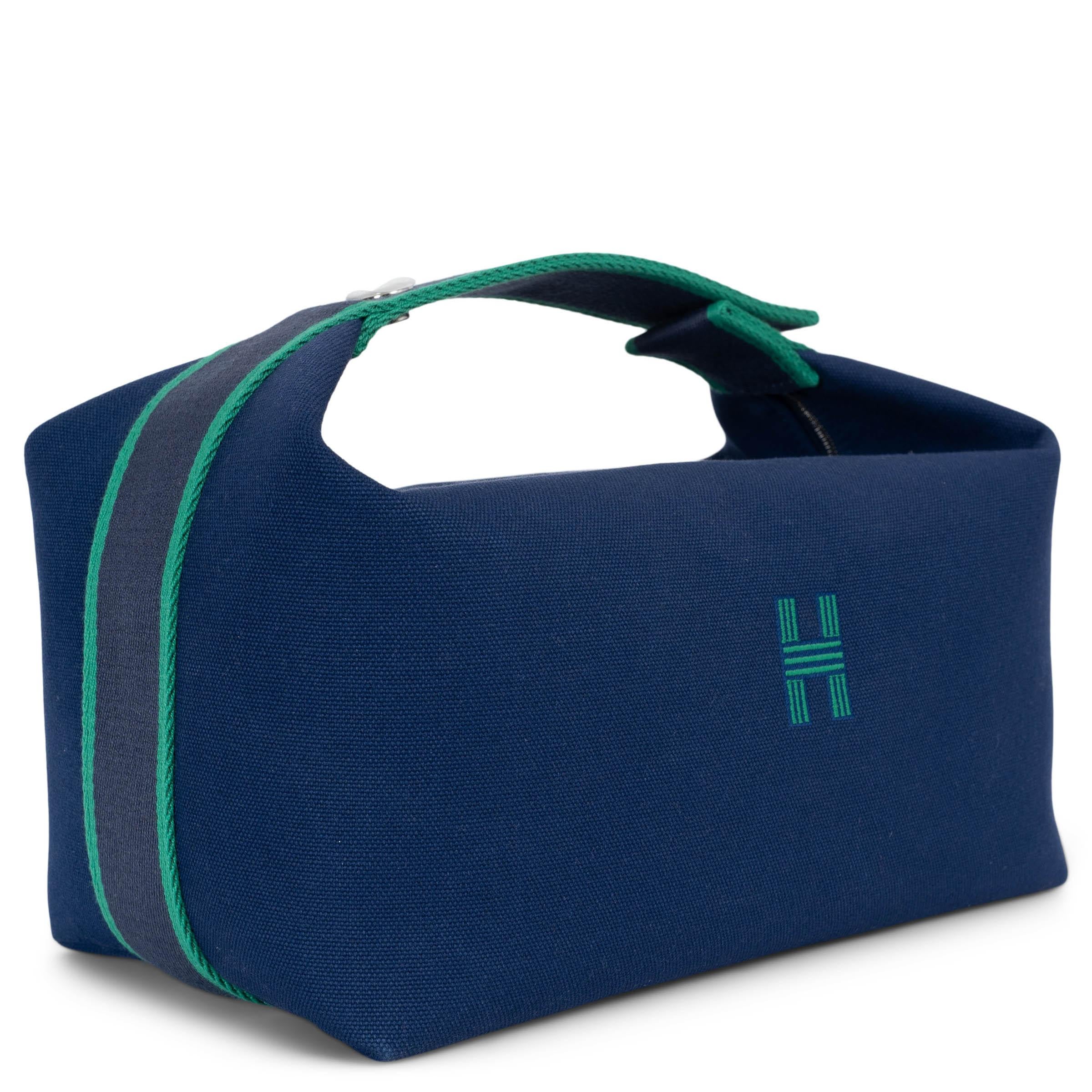 This 100% authentic Hermès Bride-A-Brac PM vanity case in Marine blue canvas is a functional yet stylish travel essential. Featuring a green embroidered 