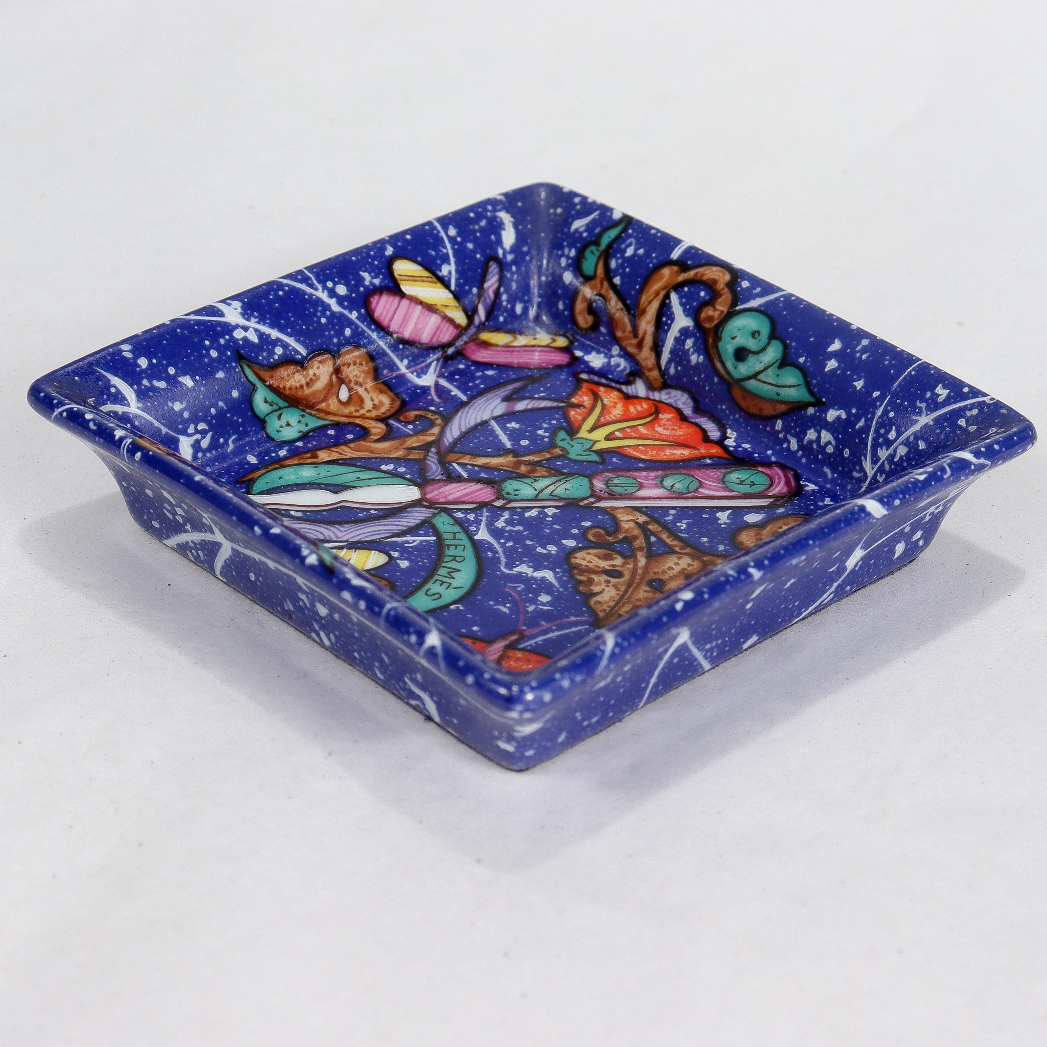 A fine porcelain small square dish.

By Limoges for Hermes Paris. 

In the Marqueterie de Pierre d'Orient et d'Occident Blue pattern.

With blue felt to the base that is marked with Hermes makers mark / Porcelain / Limoges / Made in France.

Simply