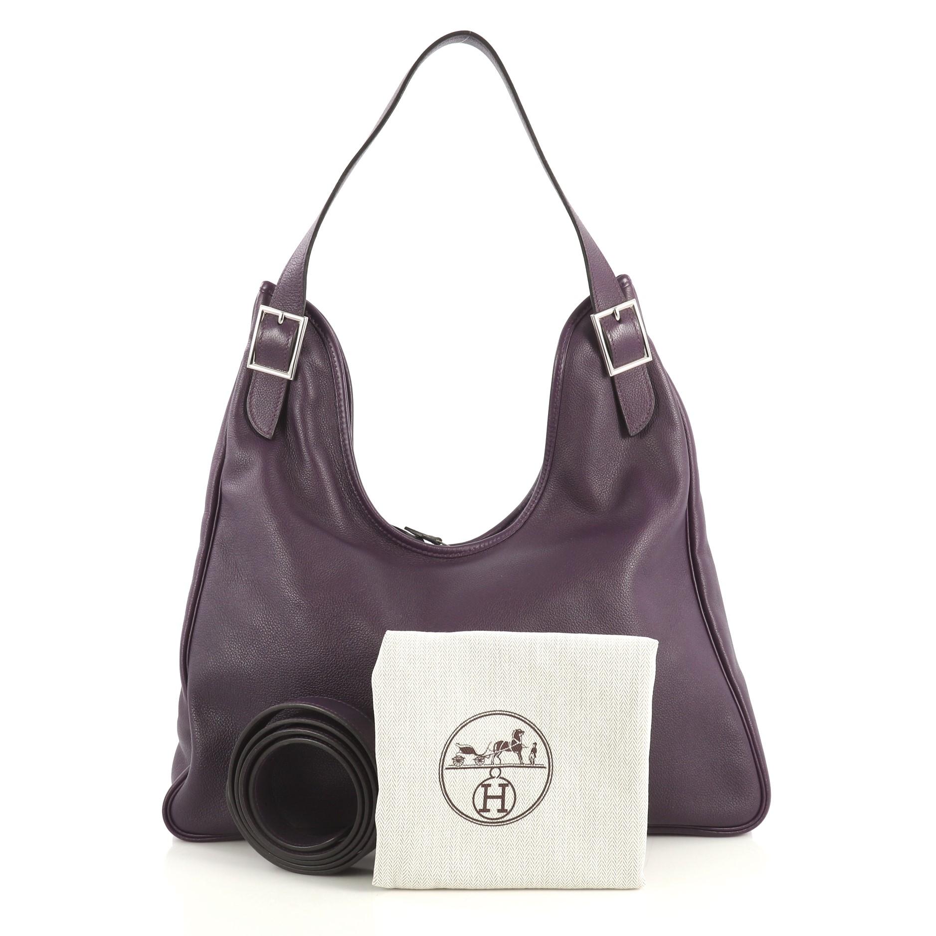 This Hermes Massai Cut Handbag Leather 32, crafted from Violet purple Evergrain leather, features a single looped shoulder strap with buckle details and palladium hardware. Its zip closure opens to an Ecru neutral Toile Chevron interior with side