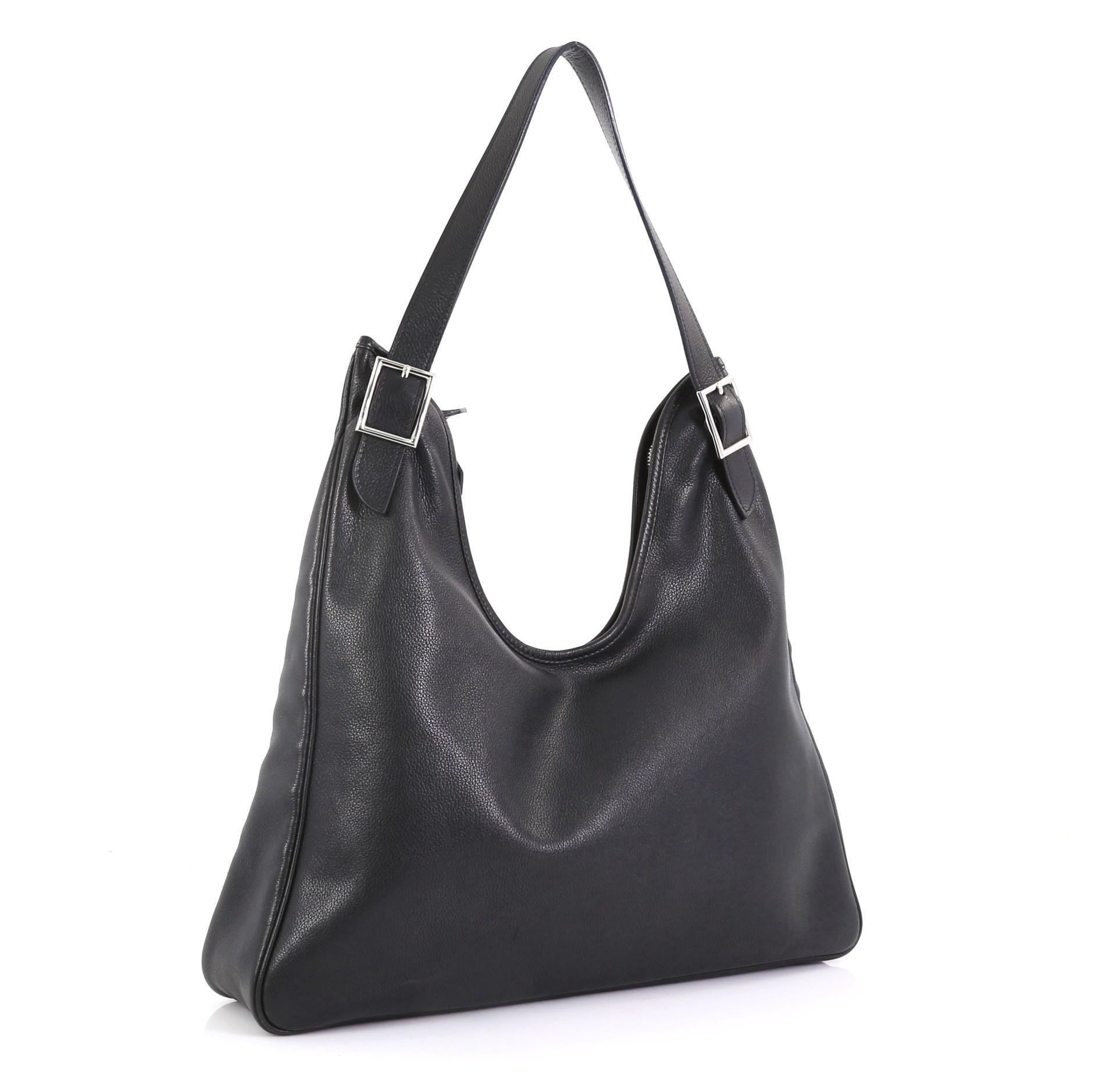 This Hermes Massai Cut Handbag Leather 32, crafted from Noir black Evergrain leather, features a single looped shoulder strap with buckle details and palladium hardware. Its zip closure opens to an Ecru neutral Toile Chevron interior with side zip