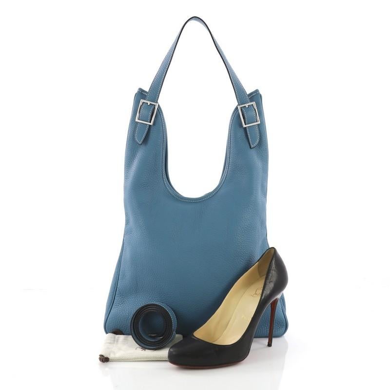 This Hermes Massai Handbag Leather 32, crafted in Blue Jean clemence leather, features a single looped shoulder strap and palladium-tone hardware. Its top zip closure opens to a beige fabric interior with zip pocket. Date code reads: K Square