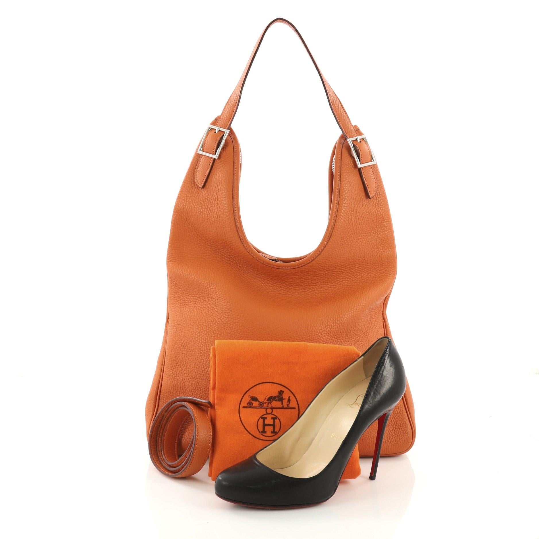 This Hermes Massai Handbag Leather 32, crafted in Potiron orange clemence leather, features a single looped shoulder strap and palladium-tone hardware. Its top zip closure opens to a beige fabric interior with zip pocket. Date code reads: H Square