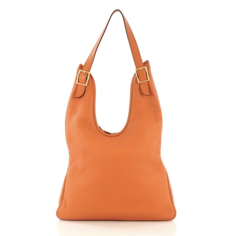 This Hermes Massai Handbag Leather 32, crafted from Orange H orange clemence leather, features a single looped shoulder strap and brushed gold hardware. The top zip closure opens to an Ercu neutral Toile Chevron interior with a side zip pocket. Date