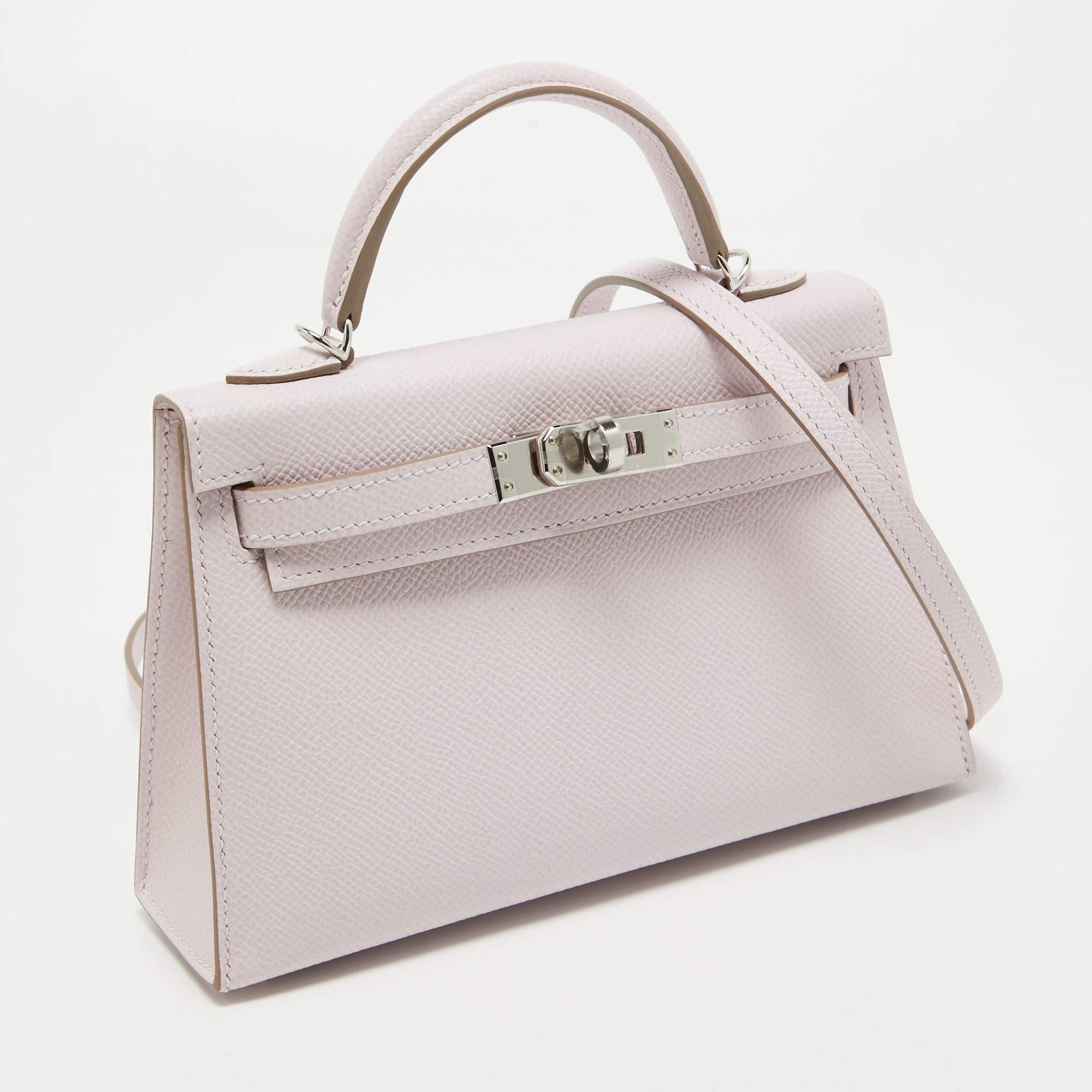 The covetable Hermès mini Kelly Sellier II Bag exudes timeless elegance. Crafted from exquisite Epsom leather in a soft mauve hue, the bag features the iconic Kelly Sellier silhouette with palladium finish hardware. Its compact size adds