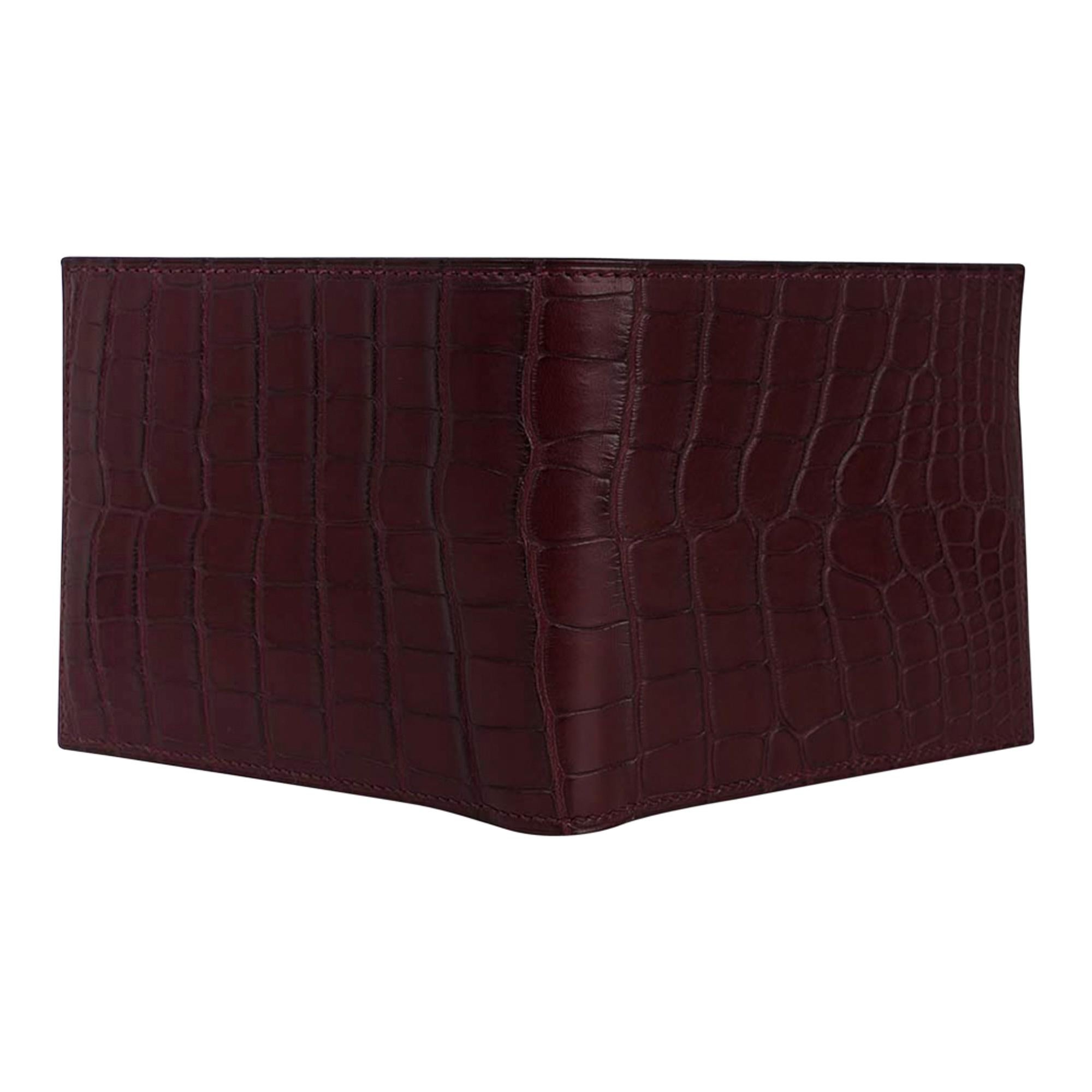 Mightychic offers an Hermes Men's MC2 Copernic compact bi-fold wallet featured in rich matte Bordeaux Alligator.
Interior is chevre with eight credit card slots, two flat pockets and one paper money slot.
Sleek clean lines.
HERMES Paris Made in