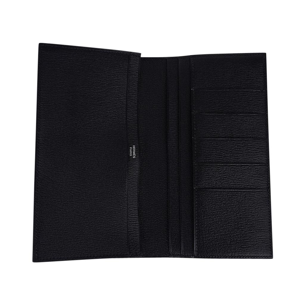 Mightychic offers an Hermes MC2 Fleming Wallet featured in Matte Black Alligator.
The interior has 5 credit card slots and 5 pockets.
HERMES PARIS Made in France embossed in interior.
Sleek clean lines.
HERMES Paris Made in France on interior