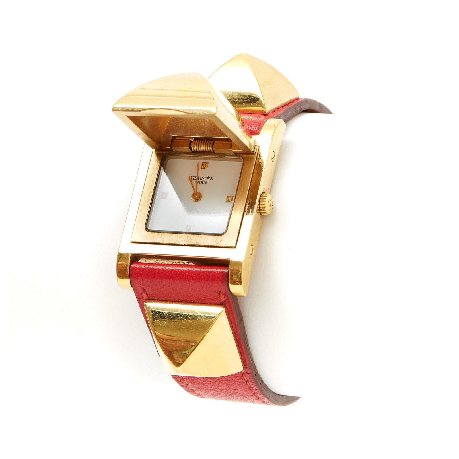 Hermès model Médor watch, steel and gold-plated metal case, white dial, gold-plated metal stud indexes at 3, 6, 9 and 12 o'clock, quartz movement, coral red leather strap (Hermès 