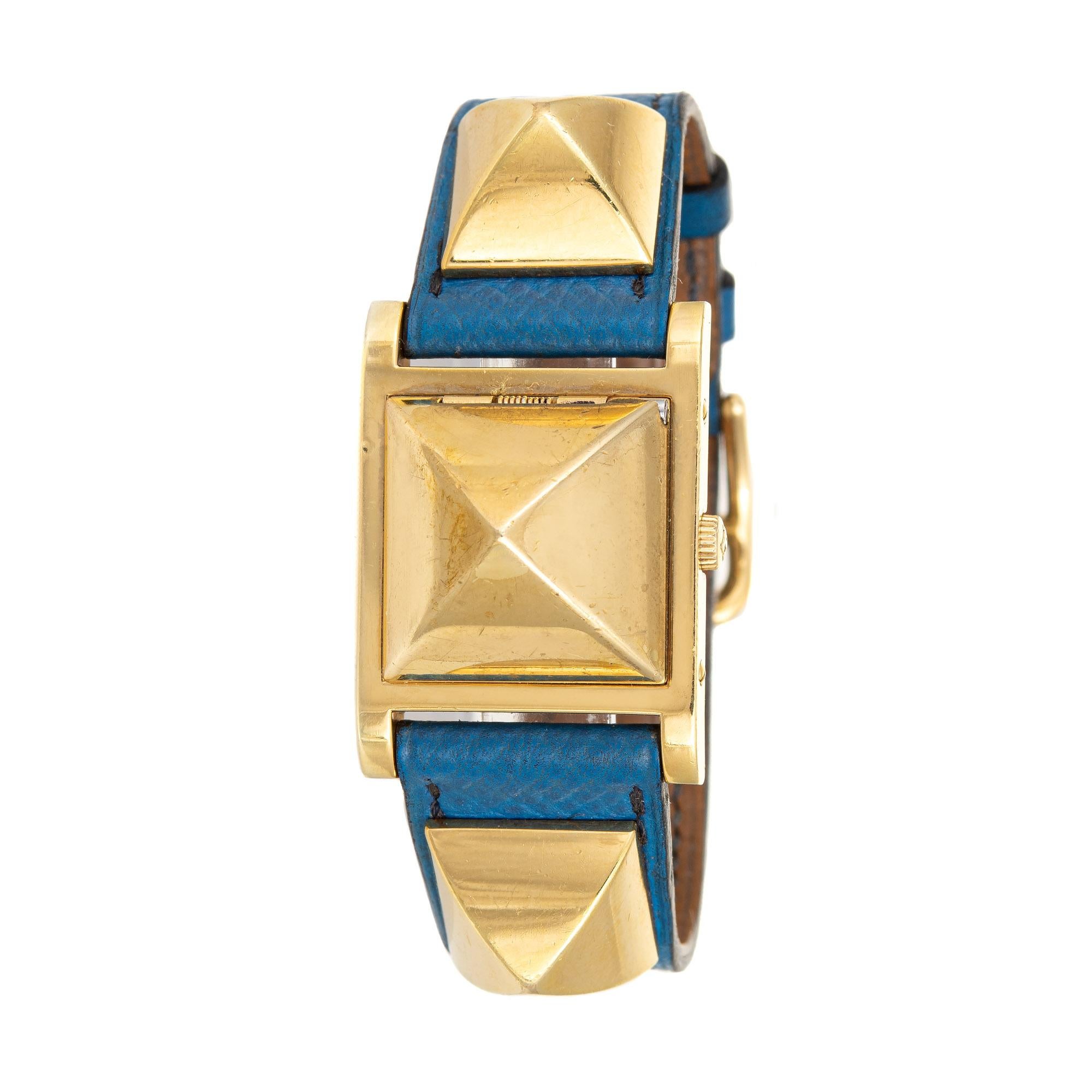 Stylish Hermes Medor wristwatch finished with yellow gold plate. 

The classic Hermes Medor watch features the original blue leather strap. The center pyramid shaped case flips open to reveal the watch dial. The watch dates to 1994 and is in good