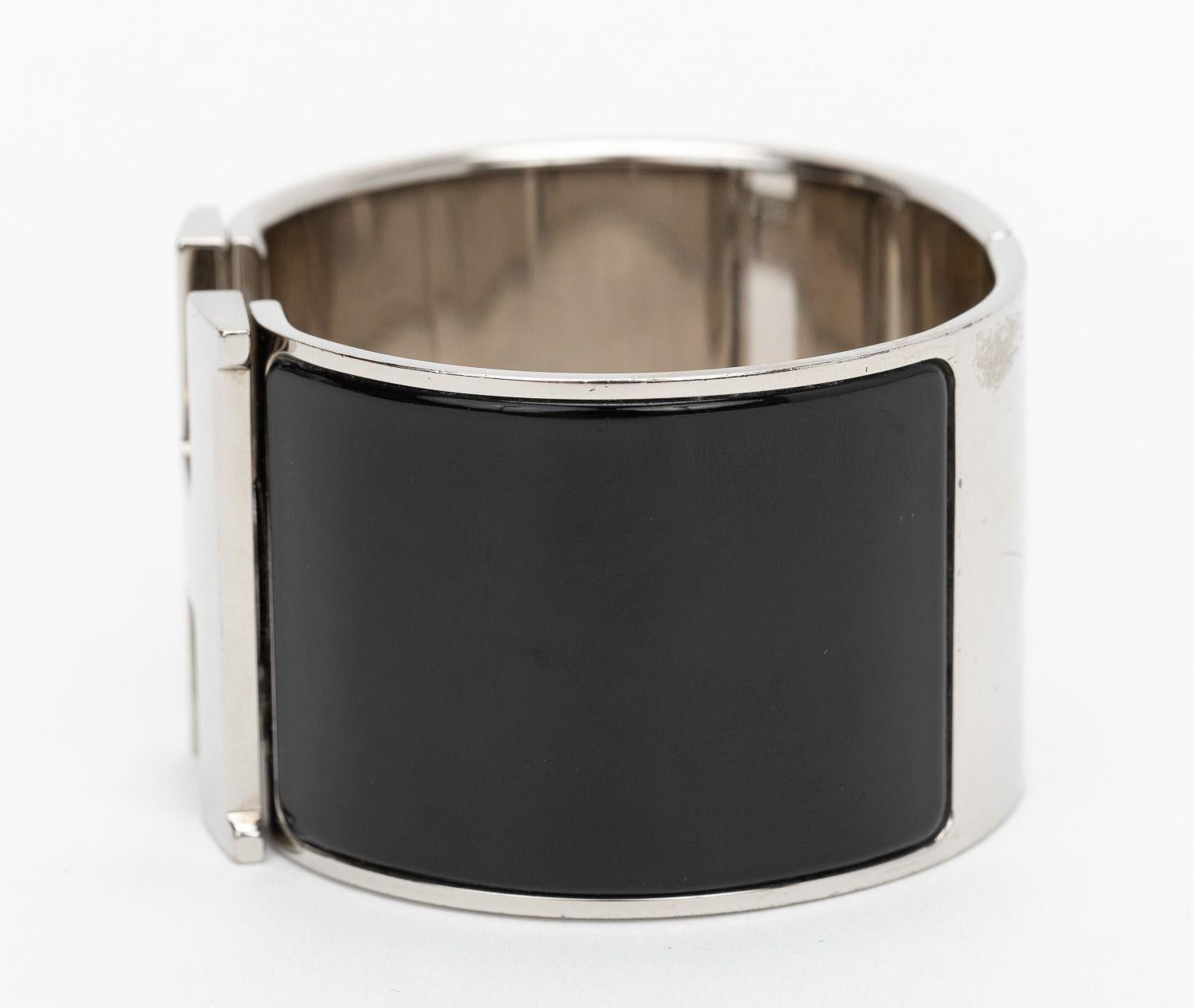 Hermès black enamel mega Clic Clac cuff bracelet. Palladium hardware. Discontinued style. Small size. Partial plastic on interior hardware, some wear throughout. Comes with original box. (slightly damaged).