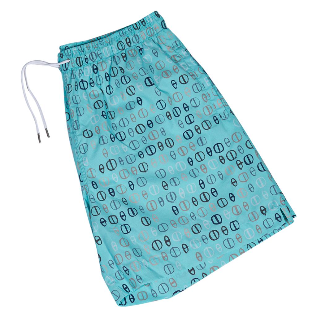 Hermes limited edition Men's Swim Trunks.
Turquoise, Grey, Black, Brown and White Chain d'Ancre print.
Elastic waist and silver metal tipped white drawstring.
2 front pockets and 1 rear pocket with Clou de Selle snap.
Lined in white.
Fabric is