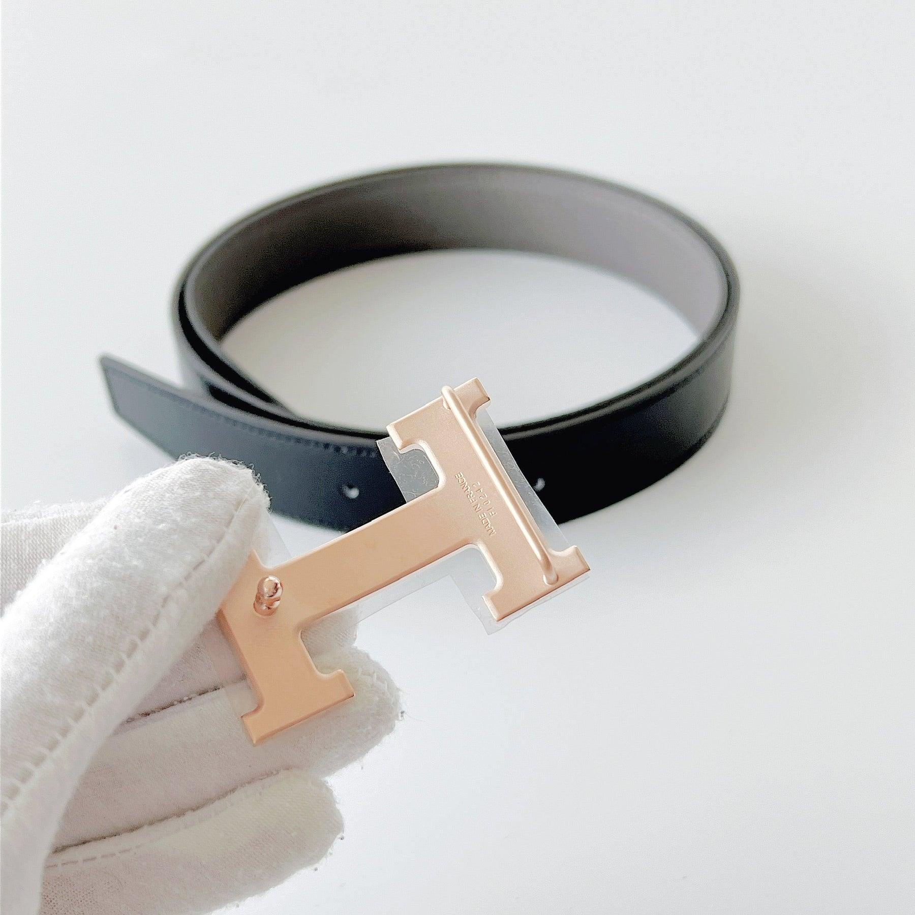 Shop this Men's Constance 'H' Reversible Belt in Black & Etain. The belt features a Rose Gold Permabrass Buckle that is changeable. The reversible leather strap, allows you to match the belt to multiple outfits. The leather strap is in box calfskin