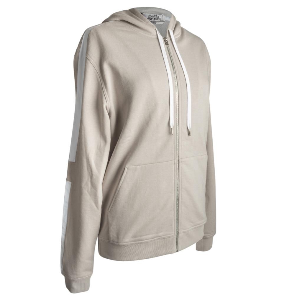 Guaranteed authentic Hermes jogging hooded zipped sweater features neutral silex.  
Beautiful neutral in cotton with contrasting insets of water resistant Toilovent.
Jacket is from the Sport Capsule collection.
Clean crisp style.
Comes with