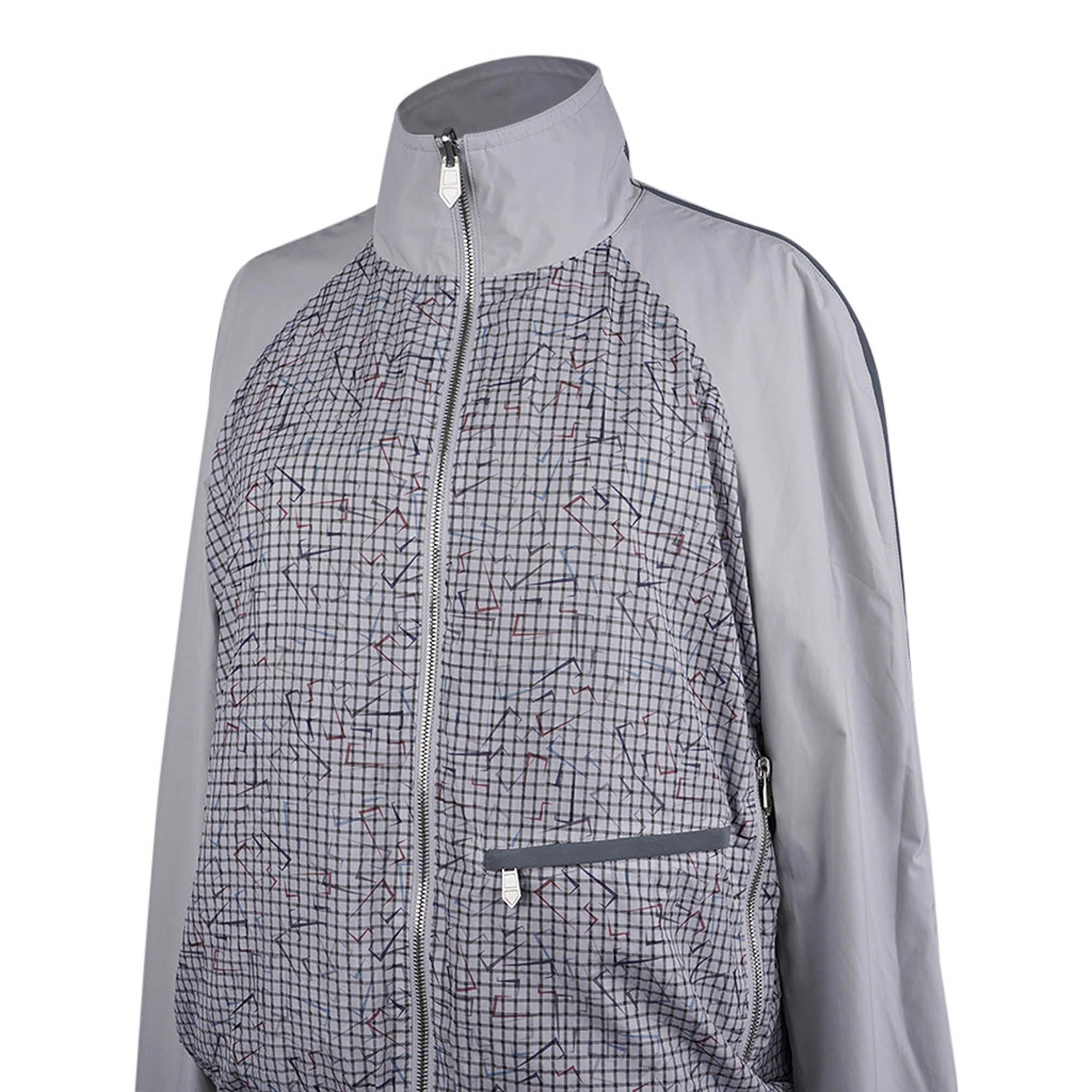 Mightychic offers an Hermes limited edition men's reversible men's windbreaker featured in Acier.
Water repellent with reflective gray accents.
The abstract logo print reverses to solid Acier.
H logo are detailed with blue and red on a grid