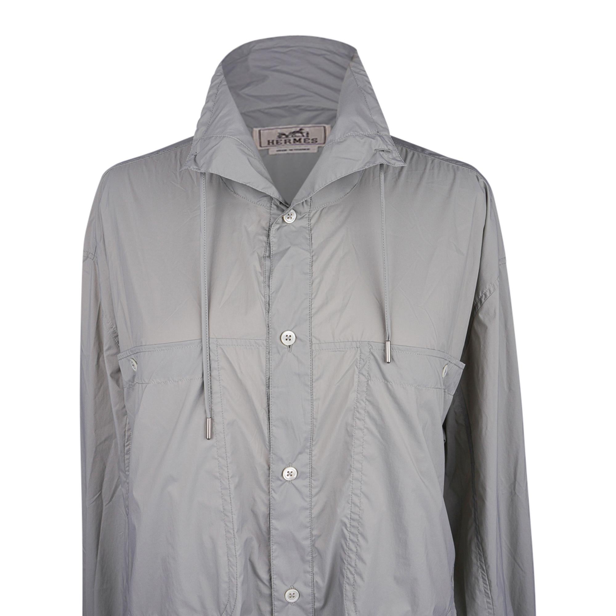 Mightychic offers an Hermes men's very lightweight technical overshirt featured in Acier.
Drawstring high collar and two front large pockets with buttons.
Two slot side pockets.
Clou de Selle buttons at cuffs.
Fabric is polyurethane.  Feather