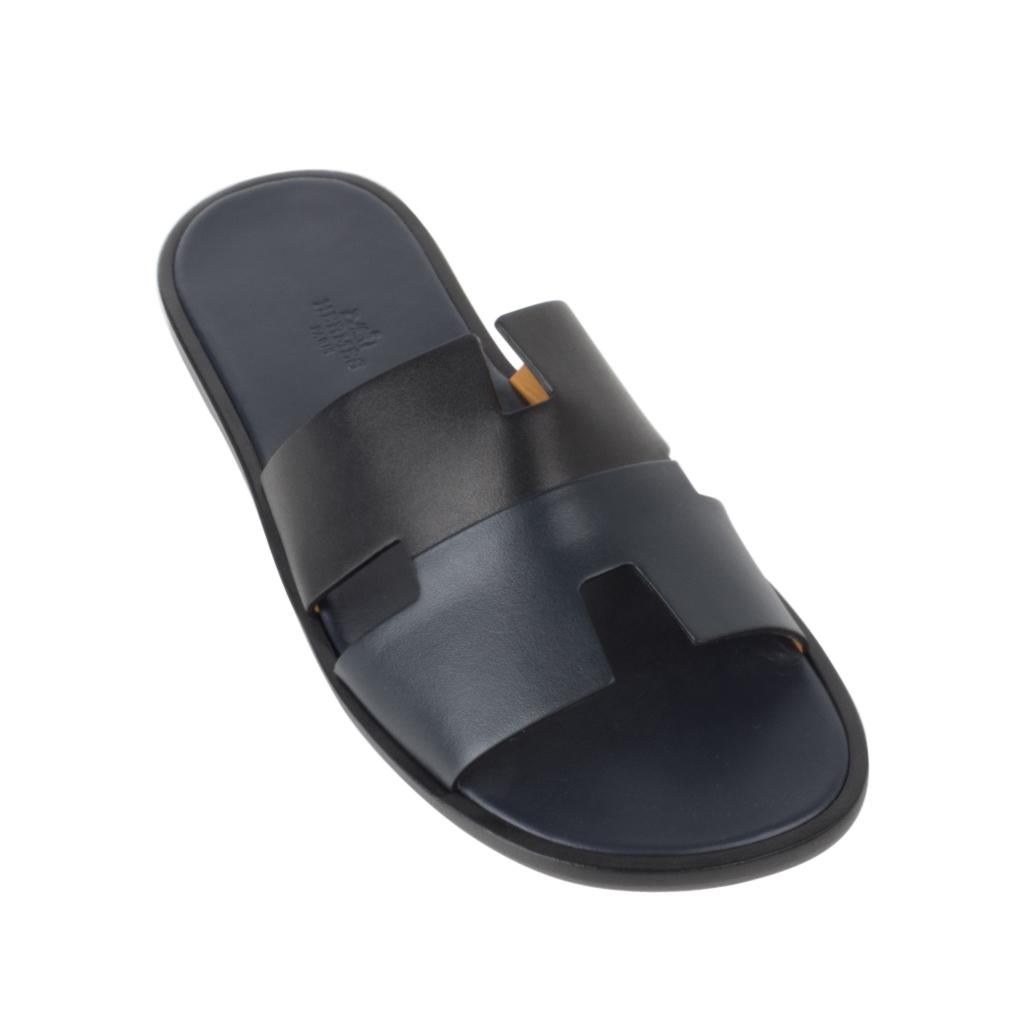 Guaranteed authentic Hermes Men's Izmir sandal features Bleu/Noir.
The iconic H cutout over the top of the foot in sublime calfskin leather.
Sophisticated colours in a silhouette that works for every wardrobe.
Insole is Blue leather. 
Wood heel with