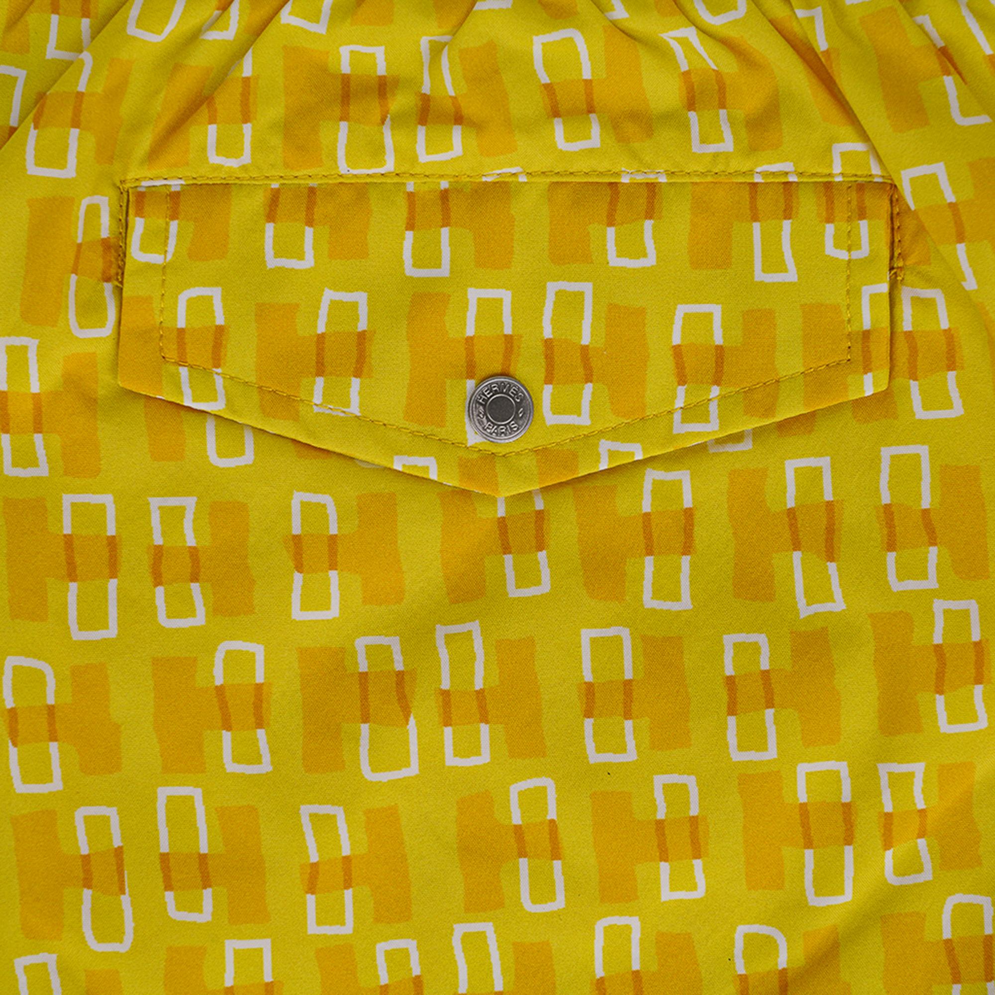 Hermes limited edition Men's Swim Trunks featured in Touches de H print.
Shades of yellow with a touch of white.
Elastic waist and silver metal tipped white drawstring.
2 front pockets and 1 rear pocket with Clou de Selle snap.
Lined in
