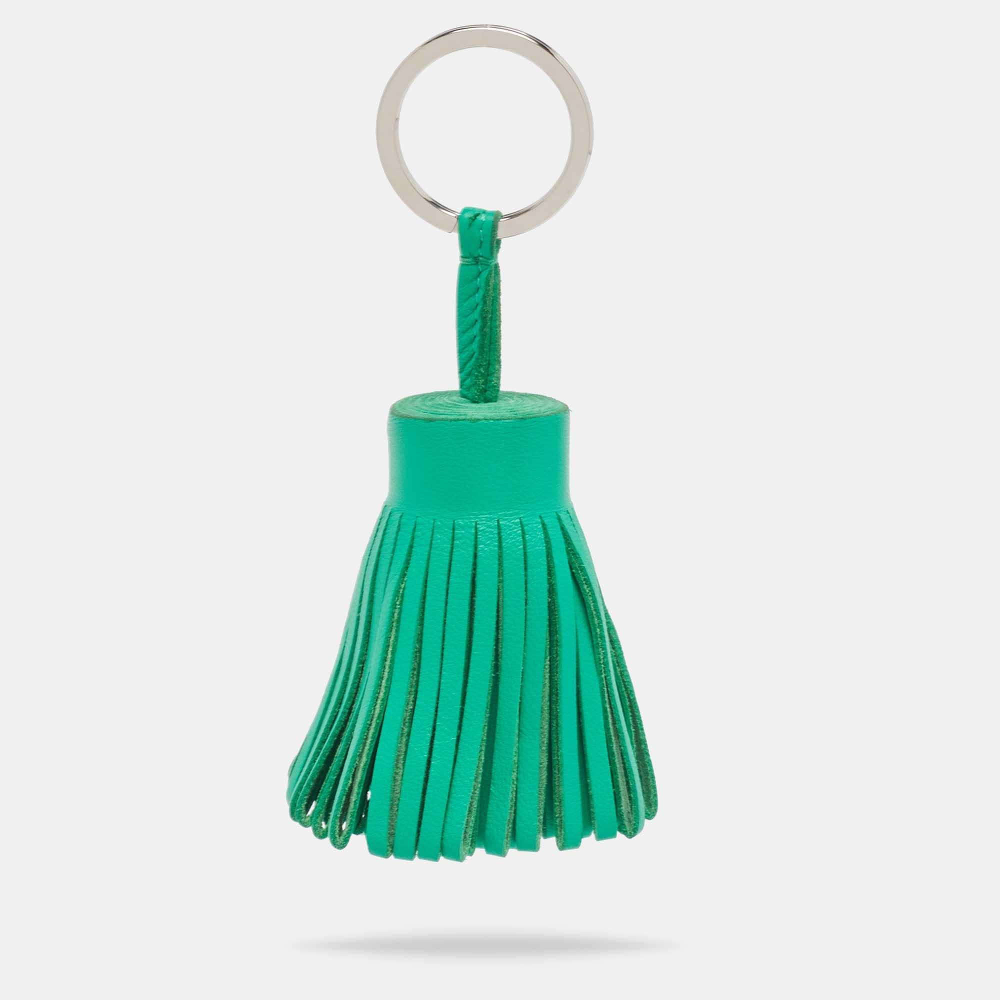 The Hermès Carmen key ring is a stylish accessory that adds a touch of luxury to your everyday essentials. Crafted from green leather, it features a tassel design and a metal ring to hold your keys.

