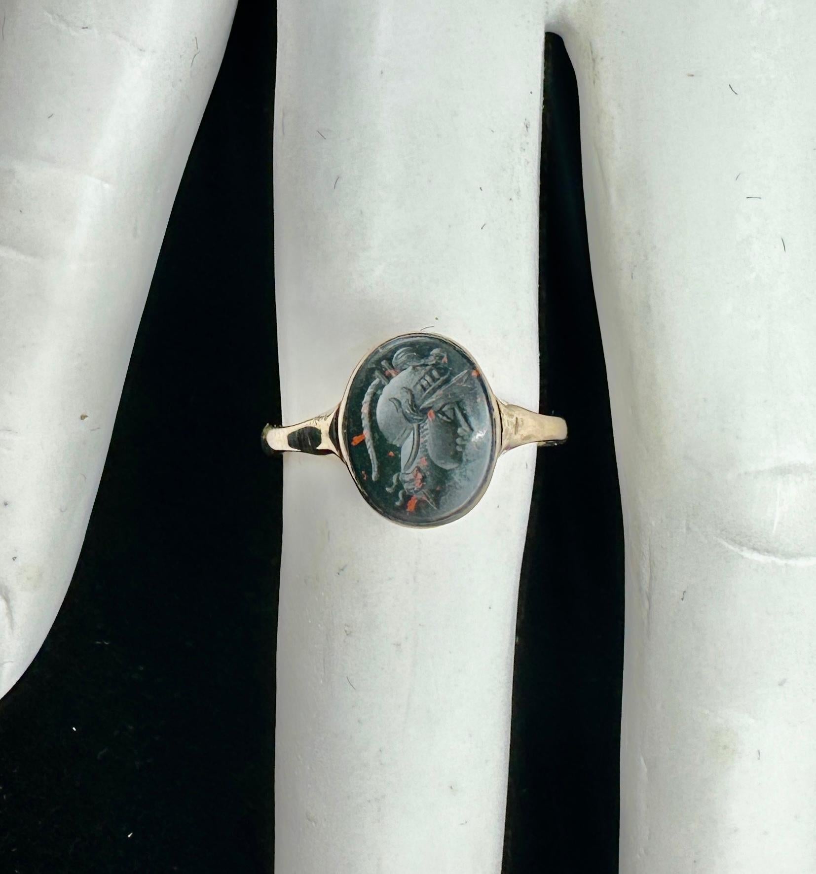 Se trata de un raro y maravilloso anillo antiguo de la Belle Epoque victoriana con una bella calcografía tallada a mano de un dios guerrero romano con casco alado, Mercurio o Hermes, en piedra de sangre.  El primer anillo es de oro de 10 quilates. 