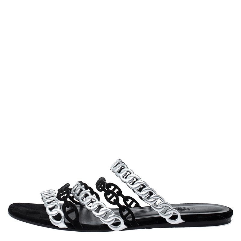 How stylish and chic do these D'ancre Chaine sandals from Hermes look! These flat sandals have an open toe silhouette featuring multiple straps across the vamps that resemble interlocking chains, rendered in metallic silver leather and black suede.