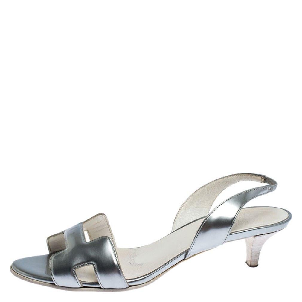 Add the classic touch to your feet with this feminine pair of metallic silver sandals from Hermes. They feature the brand's iconic H on the vamps, gorgeous stacked heels and slingbacks with buckle fastening. Slip them on over dresses for an elegant