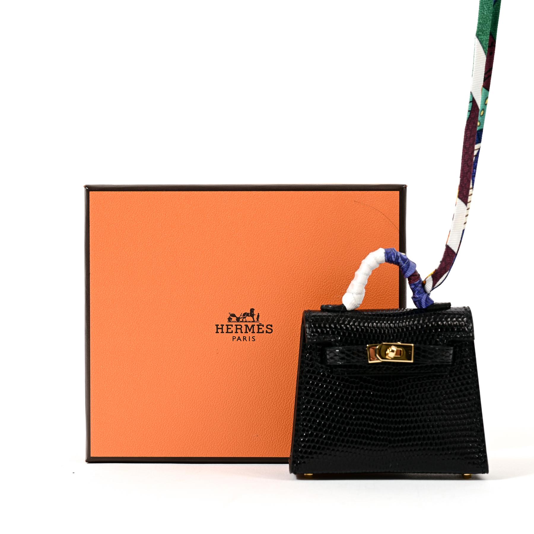 Hermès Micro Mini Kelly Twilly Charm Black Lizard GHW

Downsized from a Hermès Kelly bag, this adorable Hermès Kelly Twilly bag charm is crafted of luxurious shiny black lizard leather and features a twilly-wrapped top handle. The miniature micro