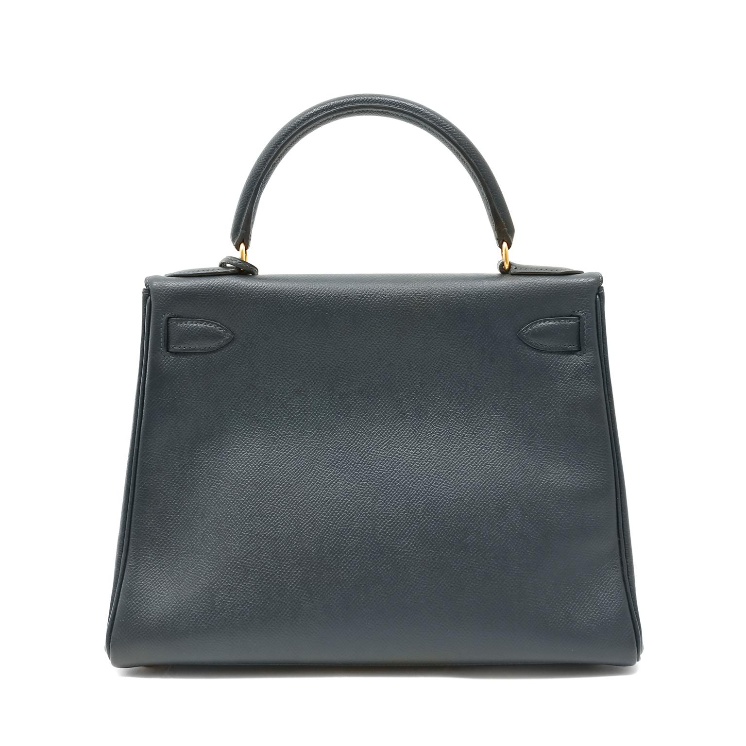 This authentic Hermès Midnight Blue Epsom Leather 28 cm Kelly is in excellent condition.  The ladylike Kelly is in high demand and requires extensive waiting periods from Hermès.  Classic deep navy blue paired with gold hardware is a timeless