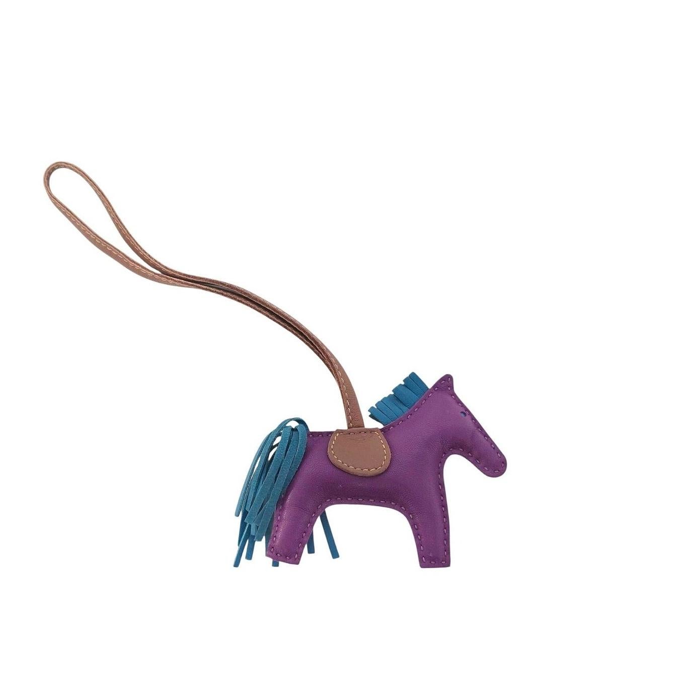 Questo squisito charme da borsa per il Cavallo Grigri Rodeo di Hermès in pelle d'agnello color anemone è realizzato a mano in Francia con una sontuosa pelle d'agnello color porpora. Questo piccolo charme è caratterizzato da una criniera e da una