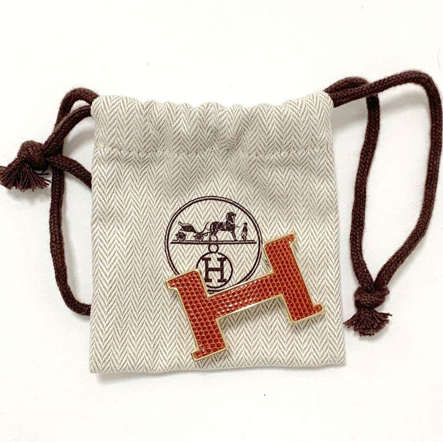 Very beautiful Constance loop of the HERMES House. It is a small model in gold plated and lizard blood color.
Very beautiful object that you can use on your leather belt.
Made in Switzerland.
Like new.
The dimensions of the H are as follows: 4.7x2.9