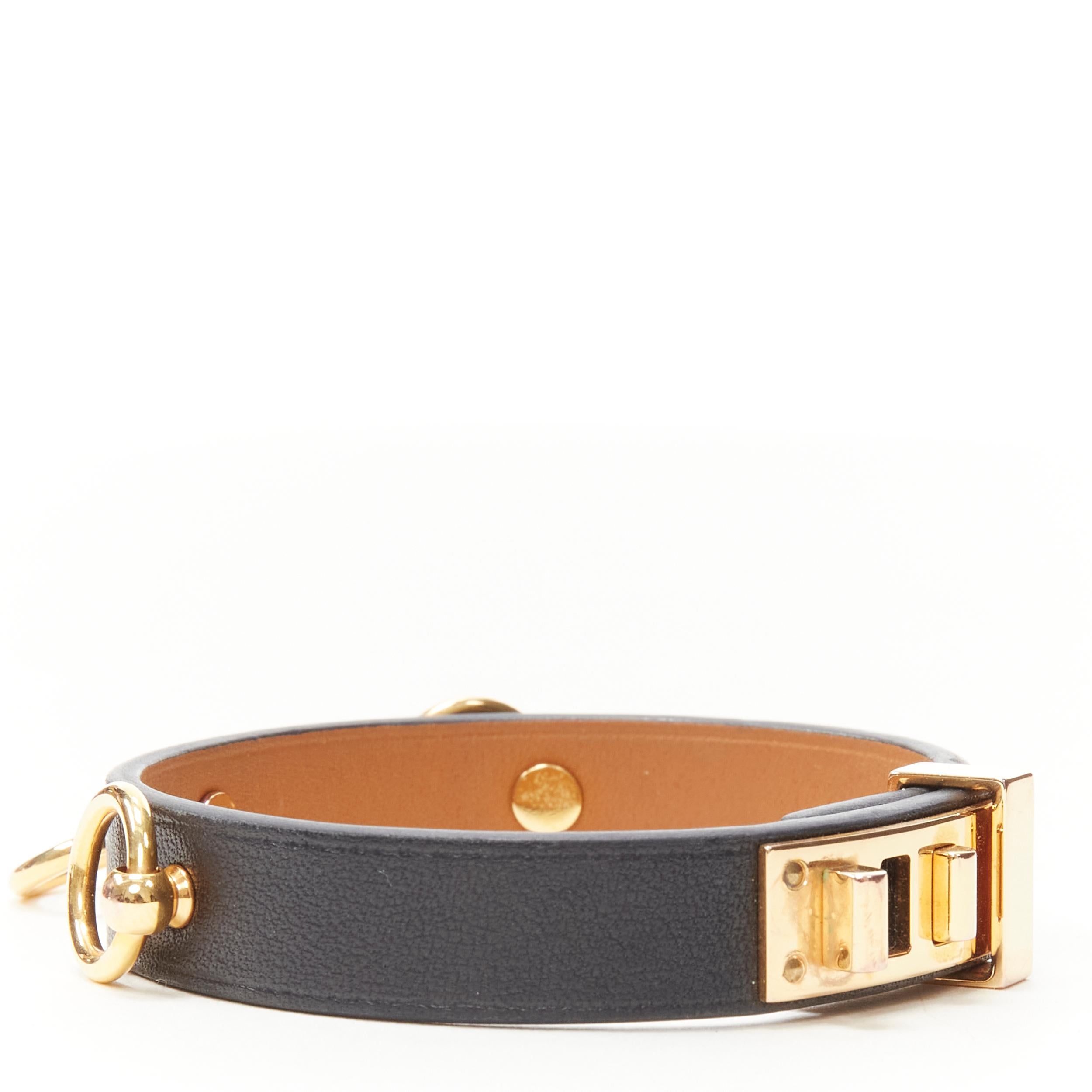 HERMES Mini Dog Anneaux black leather GHW ring embellished bracelet cuff 
Reference: KEDG/A00013 
Brand: Hermes 
Material: Leather 
Color: Black 
Pattern: Solid 
Closure: Lock 
Extra Detail: 18K Yellow Gold-Plated Brass. Black leather. 
Made in: