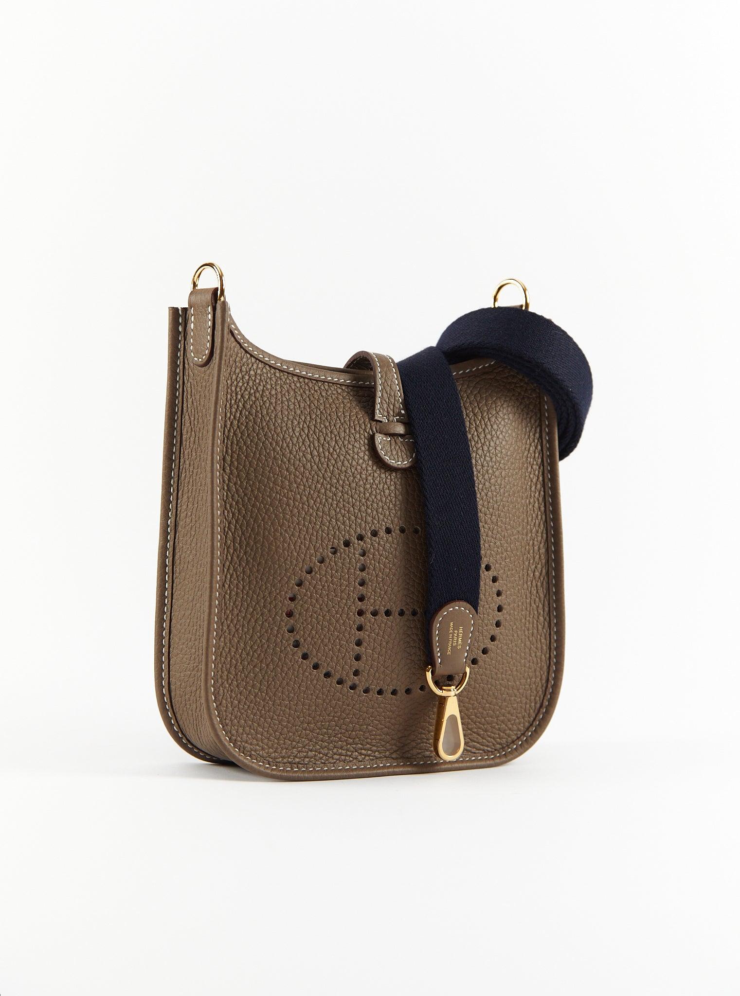 Hermès Mini Evelyn TPM in Etoupe with Blue Encre Strap

Clemence Leather with Gold Hardware

Canvas Shoulder/Crossbody strap

B Stamp / 2023

Accompanied by: Original receipt, Hermes box, Hermes dustbag, shoulder strap, shoulder strap dustbag and
