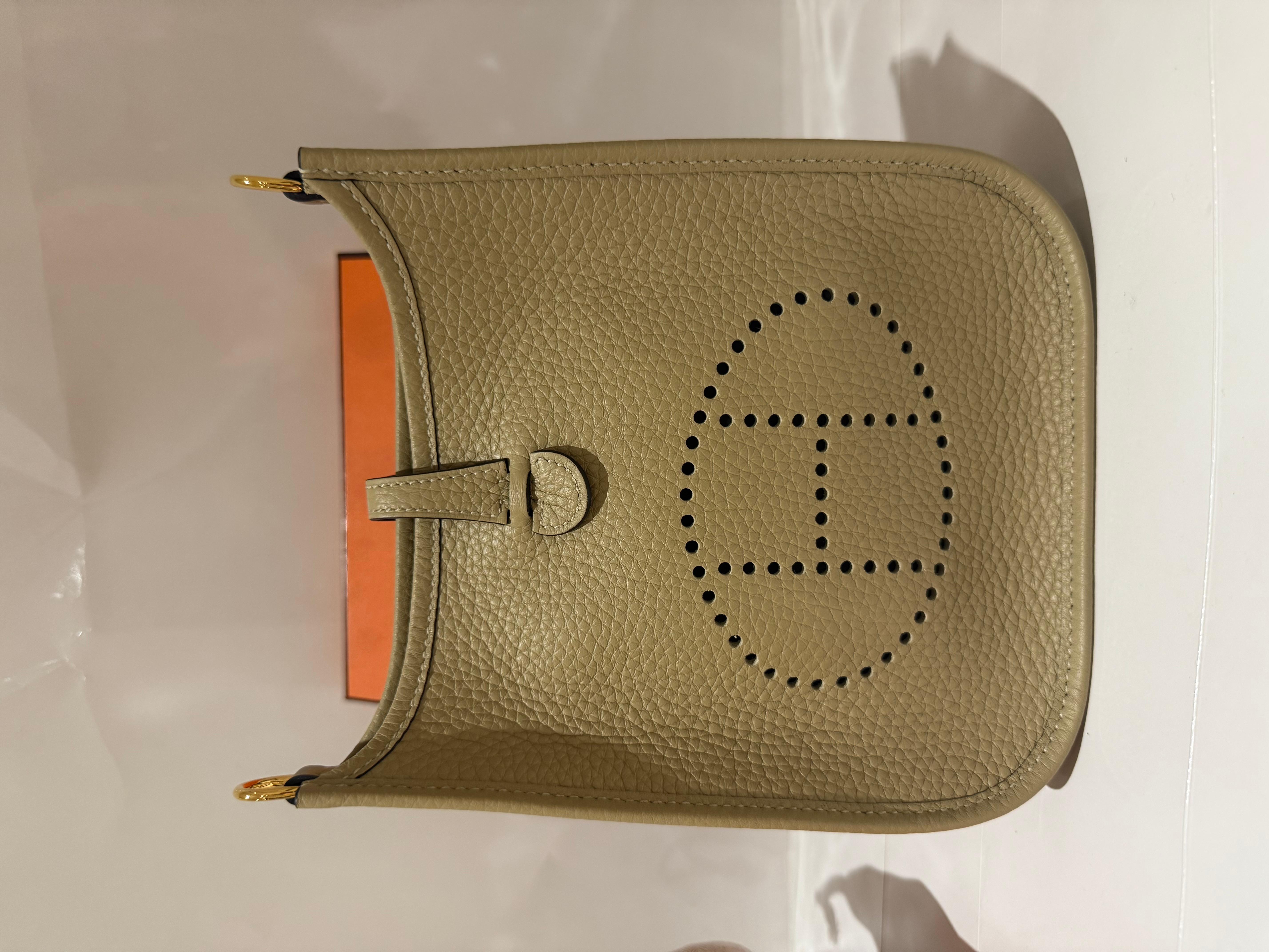 Hermes Mini Evelyne 16 in einem sehr neutralen Beige Marfa  Farbe in Clemence-Leder mit Goldbeschlägen. 
Sie wird mit einem abnehmbaren beigefarbenen Marfa-Riemen und goldfarbener Hardware geliefert. 
Perforiertes Hermès-Logo und Paris-Stempel