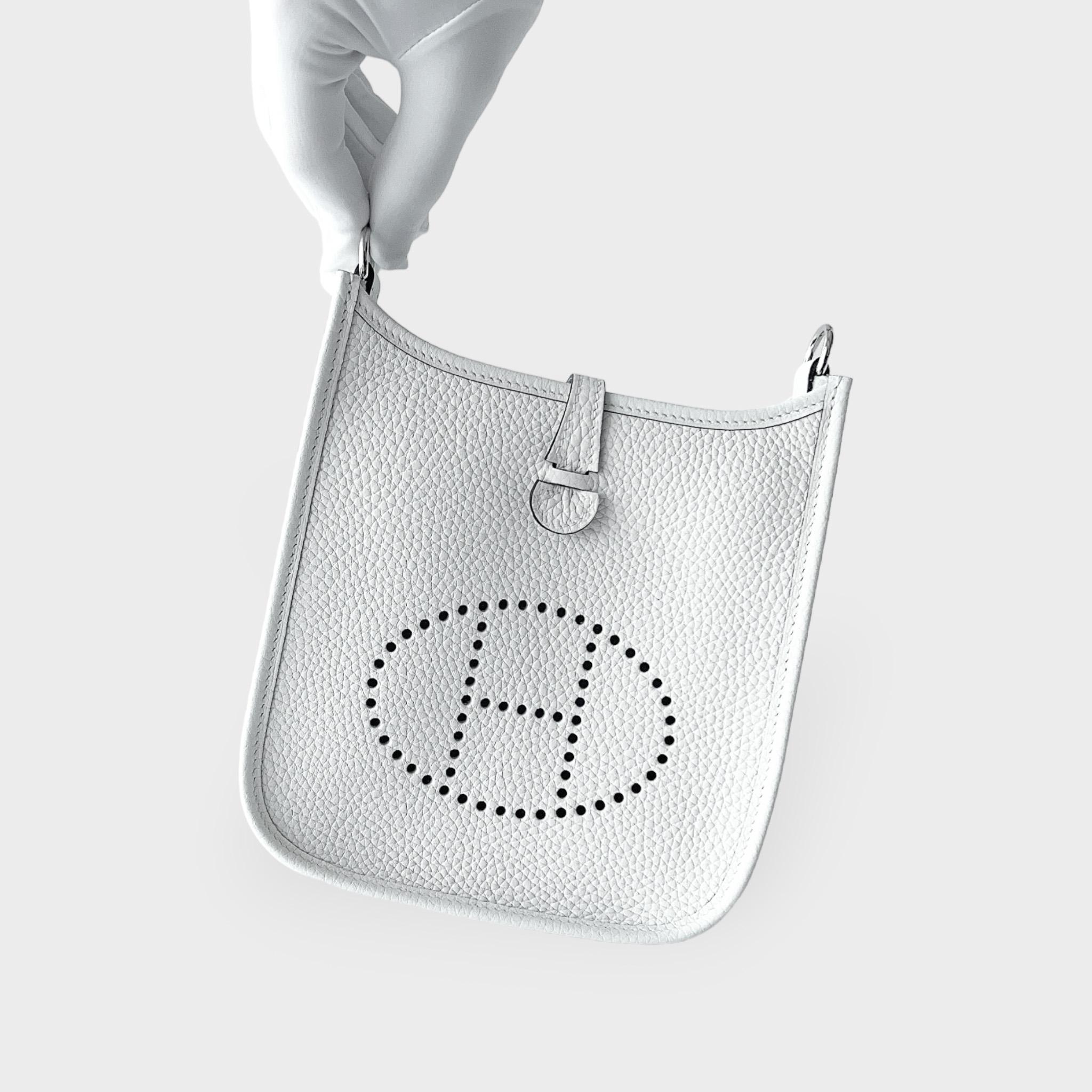 The Hermes Mini Evelyne 16 in New White is a casual design that can be used for your everyday routine. This is the smallest size Hermes Evelyne bag and is made from handcrafted New White Clemence leather, making it harder to scratch or become