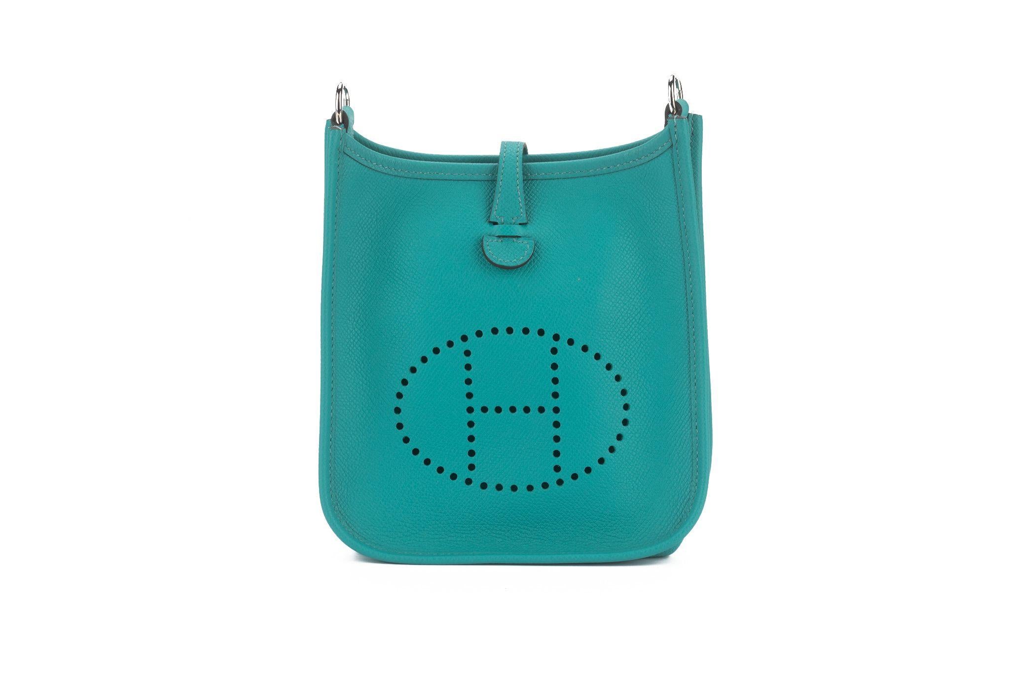 This mini Evelyne bag from Hermès has proven itself an iconic piece. This bag is featured in  blue paon epsom leather, palladium hardware, and a perforated H logo on the front. Date stamp X. Comes with booklet, double dust cover and original box.