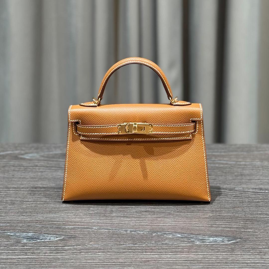 Jewels Aficionado offers the Hermès Mini Kelly 20 Sellier in Gold Epsom leather, a timeless icon in one of Hermès' most iconic neutrals. The warm caramel brown hue with contrast stitching pairs perfectly with the structured Sellier silhouette and
