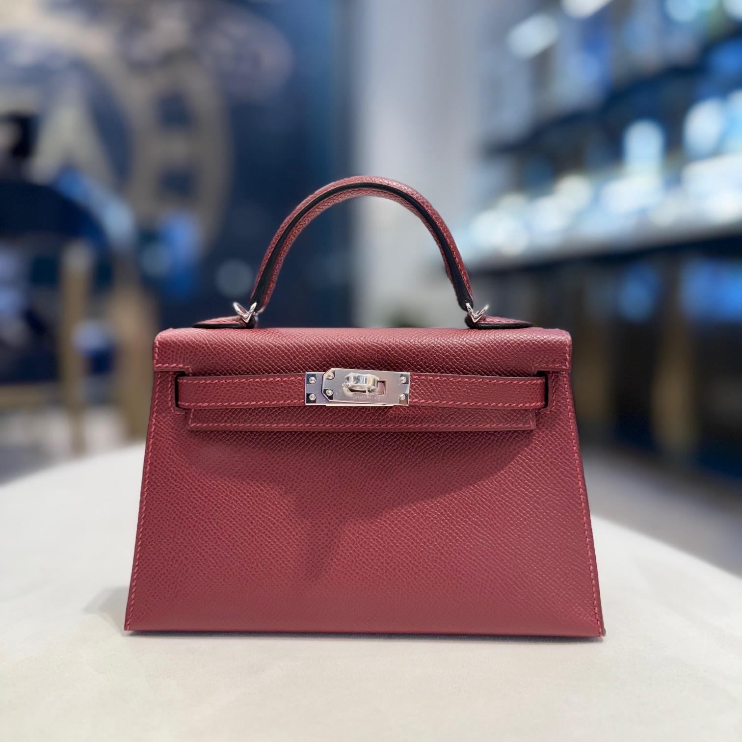 Jewels Aficionado propose Le Mini Kelly 20 Sellier Hermès Rouge H en cuir d'Epsom est une pièce sophistiquée. Sa couleur bordeaux profond respire l'élégance, tandis que la construction Eleg ajoute de la structure avec des coutures extérieures