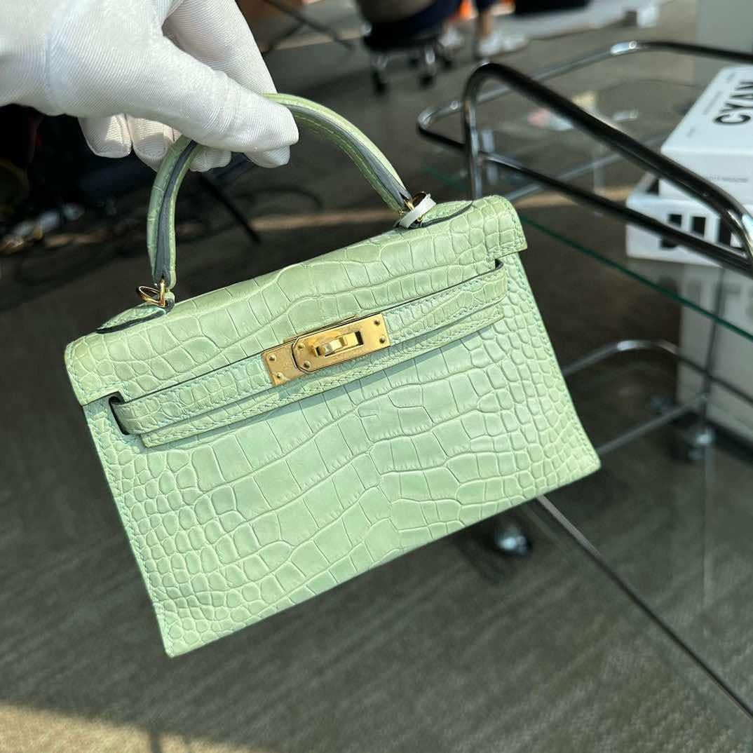 Questa Kelly di Hermes, in stile Sellier, è in pelle di alligatore opaca Vert D'Eau con finiture dorate e presenta cuciture tonali, due cinturini con chiusura frontale ad alamari, manico singolo arrotolato e tracolla rimovibile.
L'interno è foderato