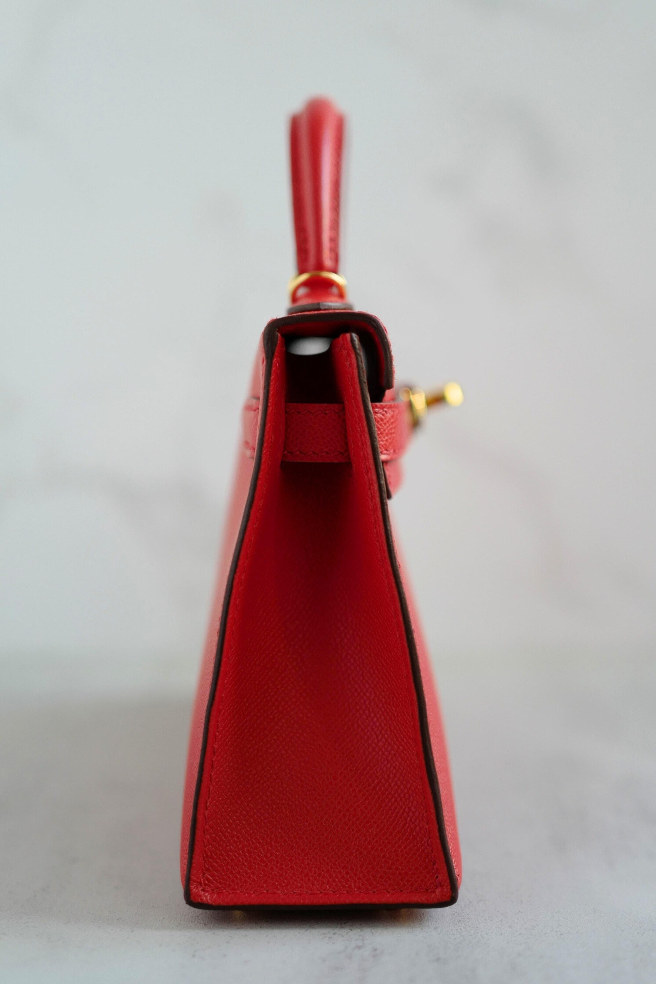 Cette exquise Mini Kelly Hermès en Rouge De Coeur est une pièce étonnante et très convoitée, fabriquée en cuir Madame luxueux et finie avec d'élégantes ferrures dorées. La couleur est un rouge riche et vibrant qui se démarque magnifiquement tout en