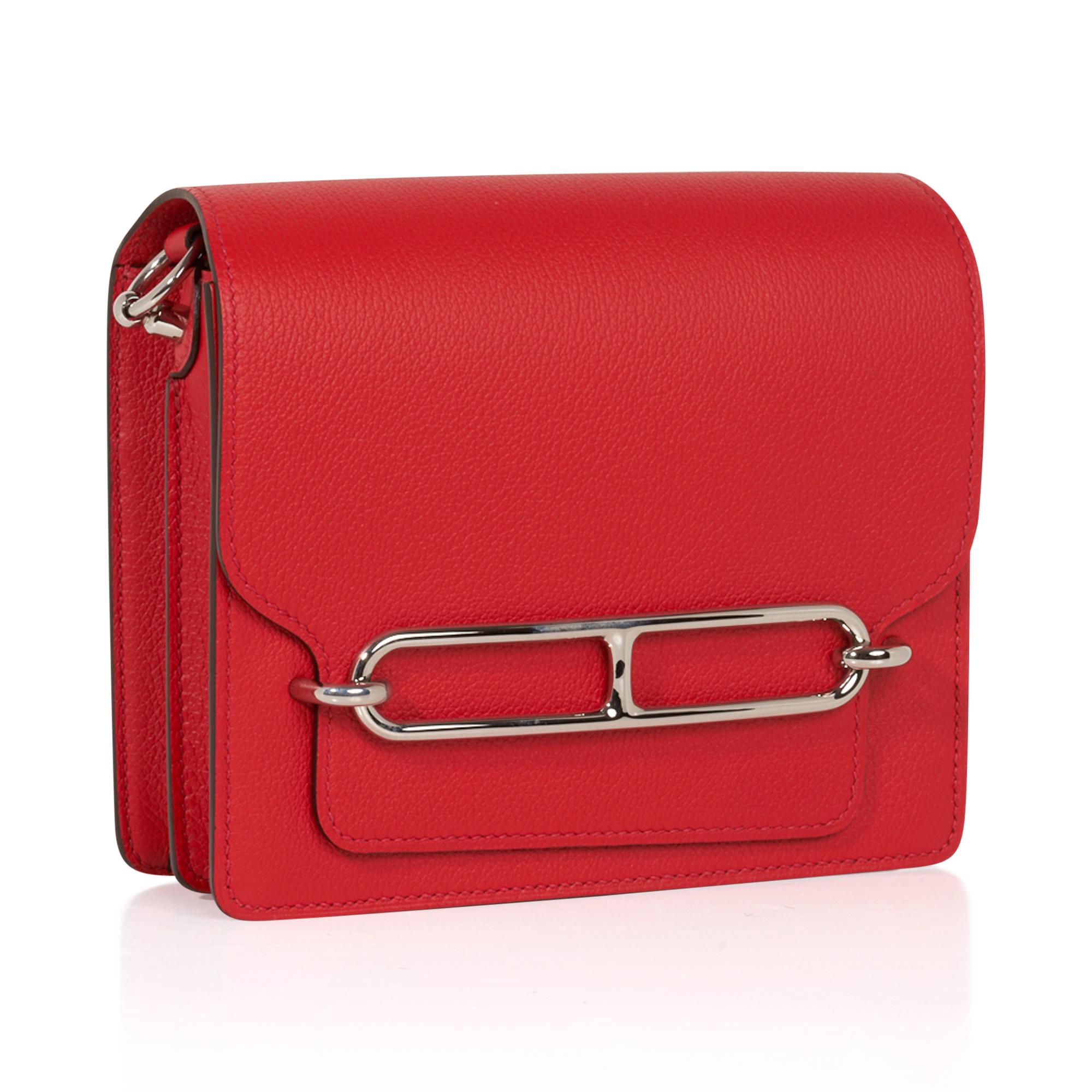Guaranteed authentic Hermes mini Roulis bag featured in pink Rouge Casaque Lipstick Red.
Evercolor leather and fresh palladium hardware. 
This divine jewel and easily moves from day to night.
Convertible from a shoulder bag to a crossbody.
Has a