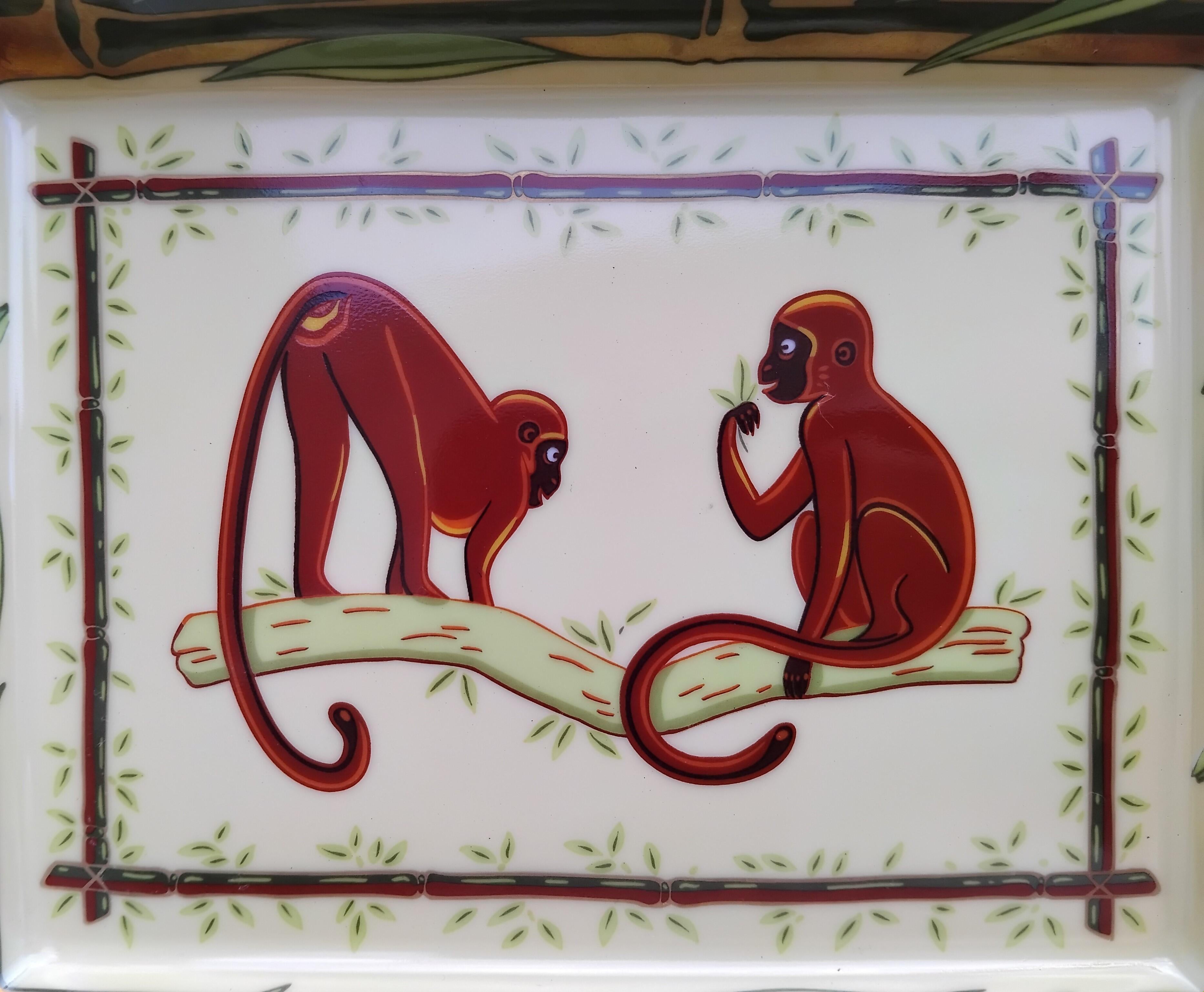 Lovely and Rare Authentic Hermès Ashtray

Print: 2 cute monkeys on a branch in a bamboo decor

Made in France

Made of printed porcelain, edges and notches handpainted with fine yellow gold

Base covered with brown suede leather, 